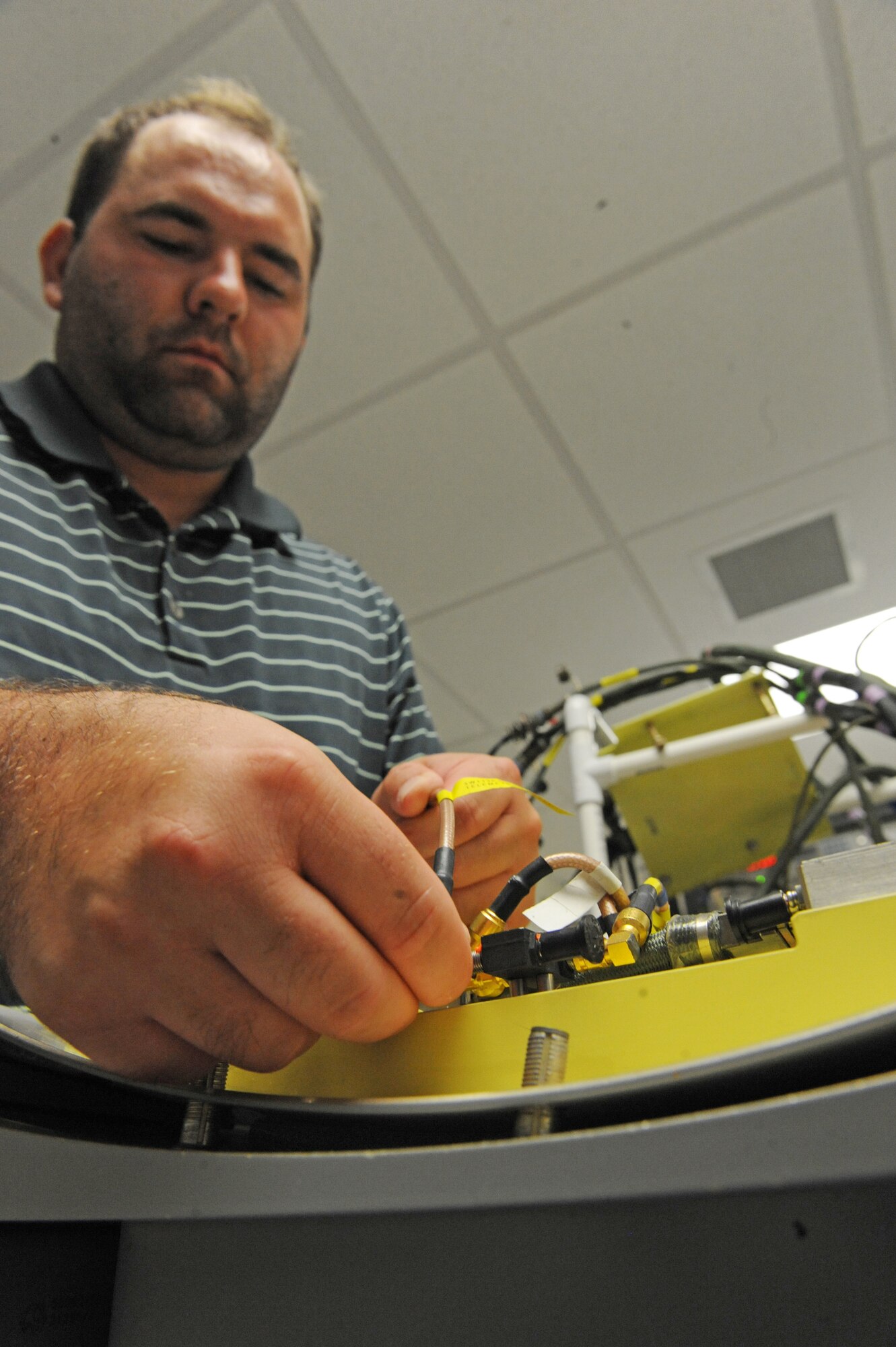 Joshuah Dolotina, electronic technician, works on a cruise missile door panel in the 49th Test and Evaluation Squadron hangar on Barksdale Air Force Base, La., Aug 9. The door panel is comprised of computers and sensors which allow the missile to communicate with the ground. It is also able to measure the missile's speed and altitude.(U.S. Air Force photo/Airman 1st Class Micaiah Anthony)(RELEASED) 