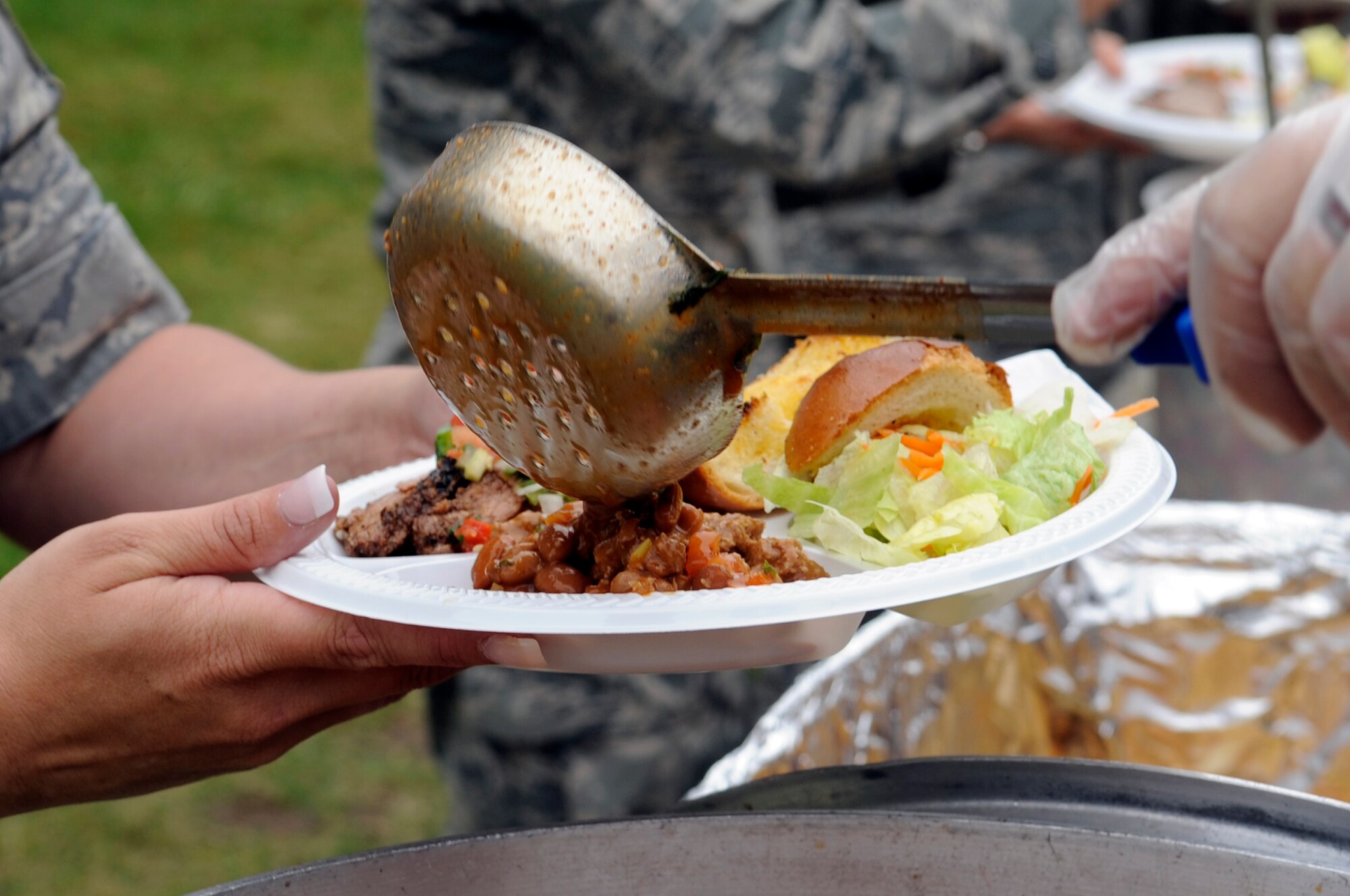 VANDENBERG AIR FORCE BASE, Calif. -- A Team Vandenberg members is served beans at an Airman’s Appreciation Barbecue held at Cocheo Park here Friday, Aug. 12, 2011.   The Lompoc Chamber of Commerce Military Affairs Committee hosts this free barbecue annually to say thank you to the service members at Vandenberg. (U.S. Air Force photo/Jerry E. Clemens, Jr.)