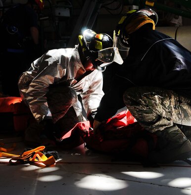 ALTUS AIR FORCE BASE, Okla. – Firefighters from the 97th Civil Engineer Squadron prepare their gear to simulate a rescue as part of fall protection rescue training in the KC-135 inspection bay Aug. 9, 2011. The 97th Maintenance Directorate trained personnel how to properly remove unconscious individuals from safety harnesses and rescue individuals who fall while performing maintenance on top of aircraft.   (U.S. Air Force photo by Staff Sgt. Marianne E. Lane/ 97th Air Mobility Wing Public Affairs-Released)