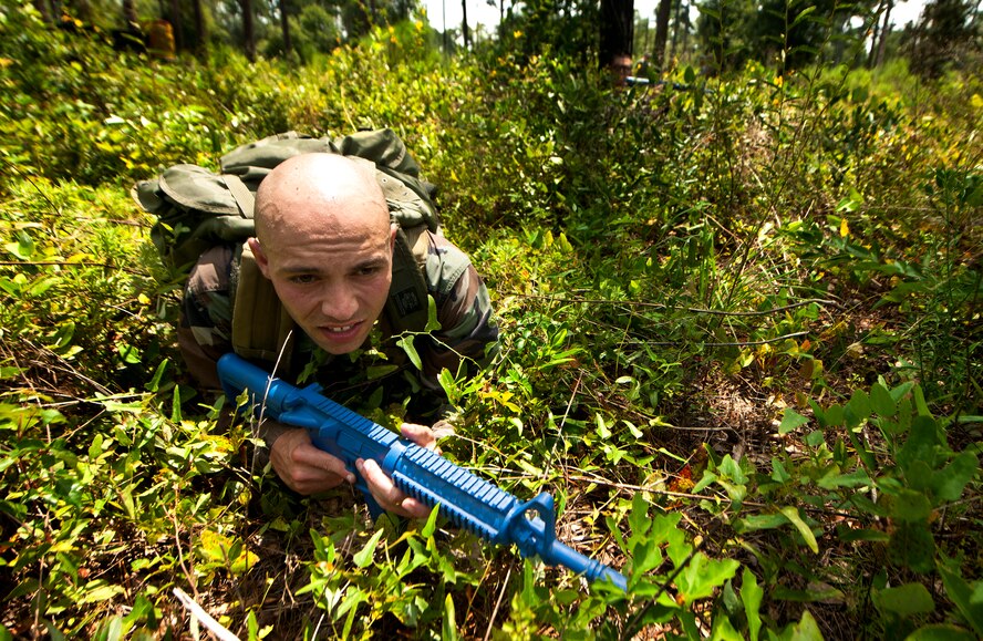 U.S. Air Force Capt. Sean Carlson, Electronic Systems Center tactical air control party program manager from Hanscom Air Force Base, Mass., lays in the grass giving perimeter cover as members of his team regroup and find a plan of action during an air liaison officer training course at Moody Air Force Base, Ga., Aug. 2, 2011. The trainees participated in a week-long course to see if they qualified for further schooling. (U.S. Air Force photo by Airman 1st Class Joshua Green/Released)
