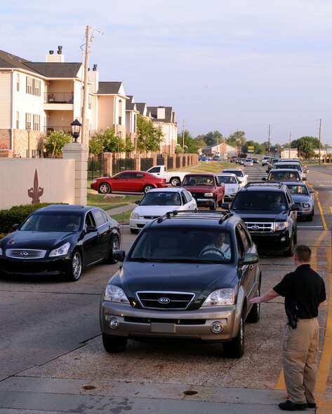 Cars line up at the North Gate as Andrew Hallead, 2nd Security Forces Squadron prepares to stop a vehicle on Barksdale Air Force Base, La., August 10. All Barksdale personnel are required to show their identification card before entering the base. (U.S. Air Force photo/Senior Airman La'Shanette V. Garrett) (RELEASED)