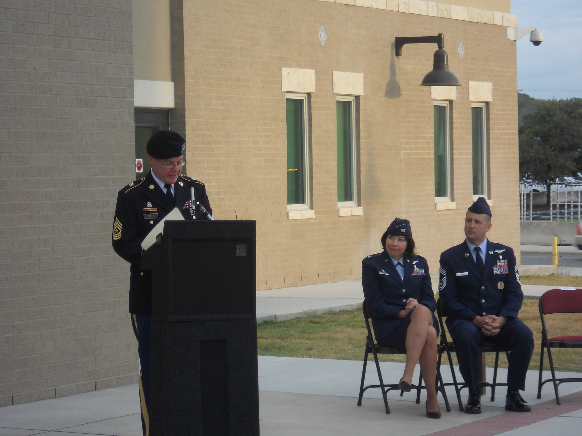 Army Sergeant Major Dan Smith, son of the late Chief Raymond T. Smith, addresses the audience during the METC Smith Hall facility dedication on Aug. 12, 2011 at Fort Sam Houston, as Col. Lista M. Benson, 882d Training Group commander and Chief Master Sgt. Charlie Cole, Chief, Medical Enlisted Force look upon.  Chief Smith was the nation’s first Sergeant Major for the United States Air Force Medical Service. (U.S. Air Force photo/Jon Stock)