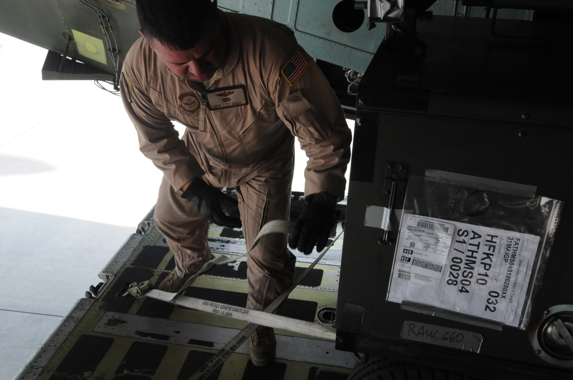 Master Sgt. Lonny Zuniga, 22nd Airlift Squadron aerial porter, from Travis Air Force Base Calif., secures cargo on a C-5 Galaxy Aug. 11 at Aviano Air Base, Italy. The 22nd ALS arrived here for a transport mission.(U.S. Air Force photo/Airman LaVel Sterling)