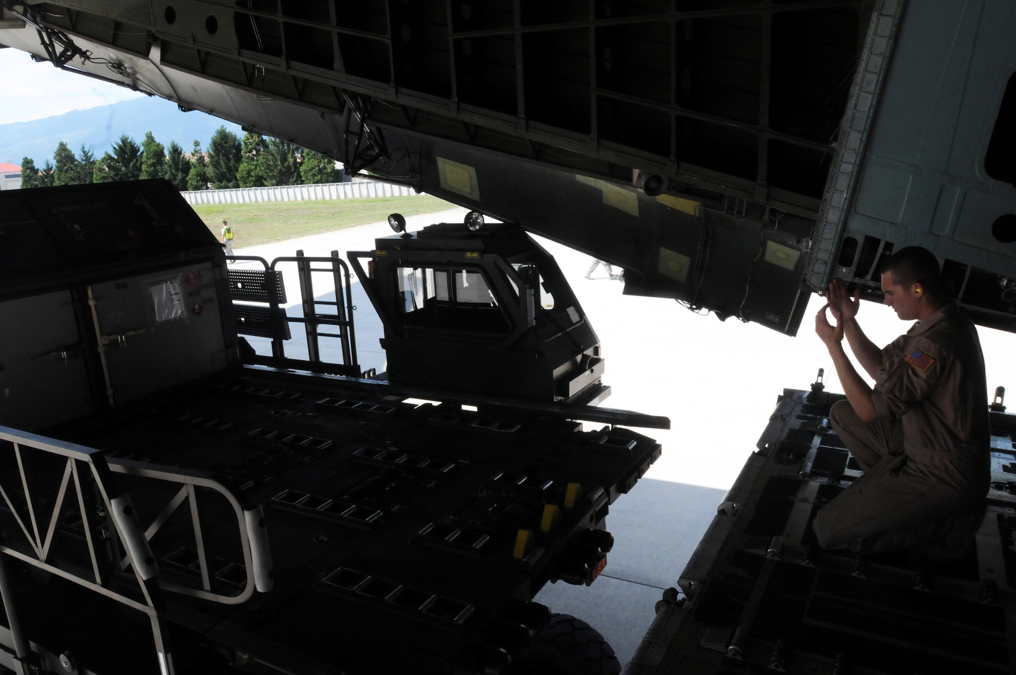 Airman Daniel Erickson, 22nd Airlift Squadron aerial porter from Travis Air Force Base, Calif., guides a cargo loader into a C-5 Galaxy  Aug. 11 at Aviano Air Base, Italy. As an aerial porter, Erickson ensures all cargo documentation, packaging, labeling and marking requirements, and all border clearance requirements have been met. He also checks all cargo against manifests, and annotates all overage, shortage, or damage, and secures cargo with appropriate devices and equipment.(U.S. Air Force photo/Airman LaVel Sterling)
