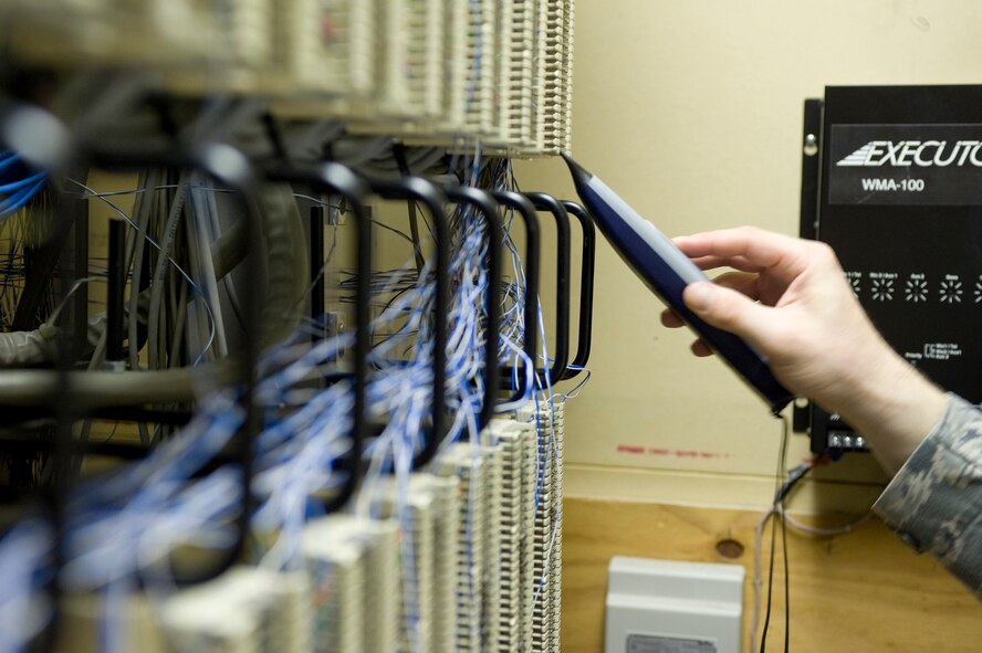 Airman 1st Class Stephen Sovine, 2nd Communications Squadron, uses an amplifier to locate a telephone port on Barksdale Air Force Base, La., Aug. 10. Before installing a phone, Sovine must determine which terminal in the closet corresponds to the telephone port. (U.S. Air Force photo/Senior Airman Chad Warren)(RELEASED)