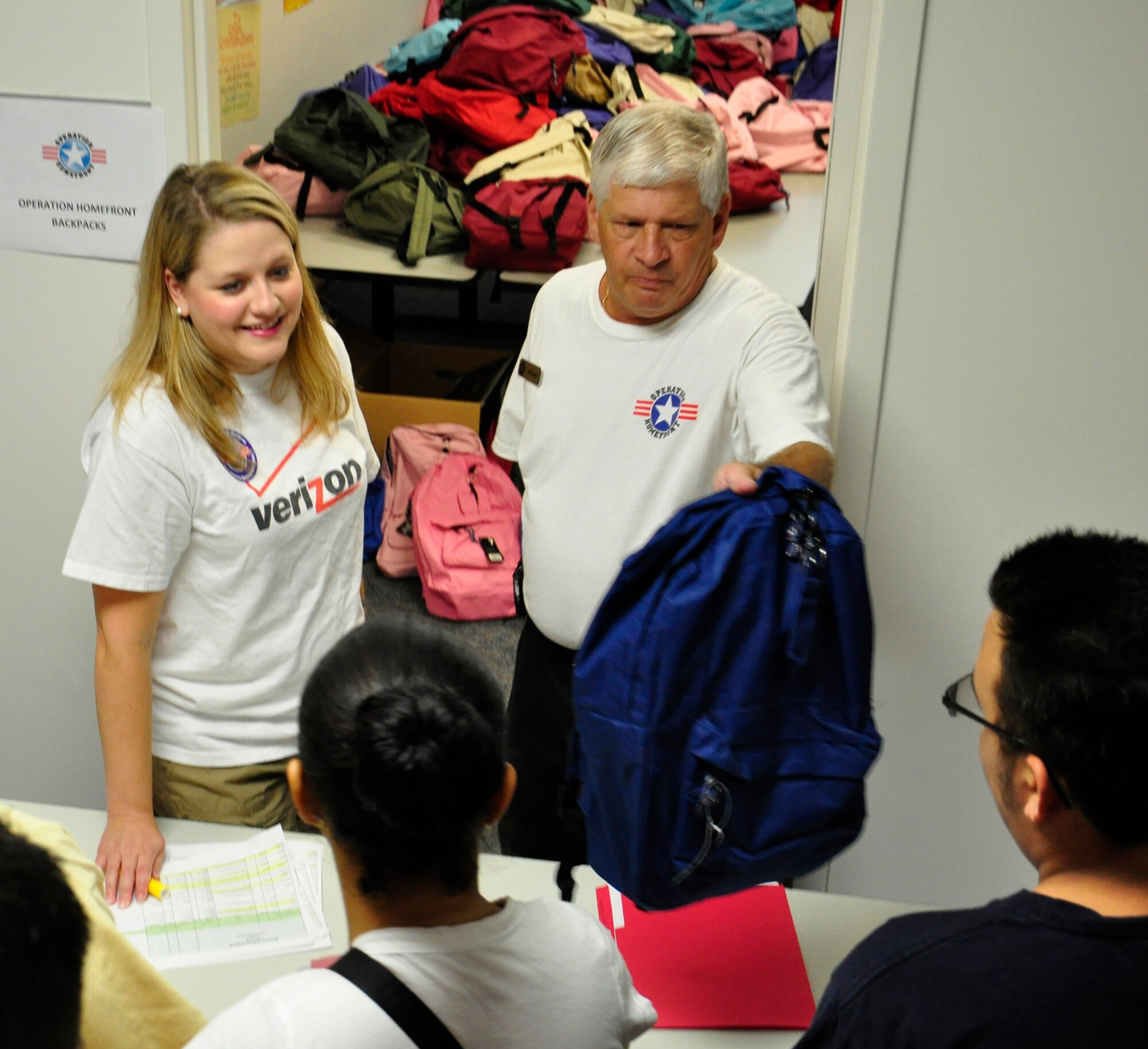 Jack Garea, Operation Homefront Director of Operations, and Julie Smith, Operation Homefront volunteer, give away backpacks during the Back to School Fair at MacDill Air Force Base, Aug. 6, 2011. (U.S. Air Force photo by Airman 1st Class Michael Ellis)