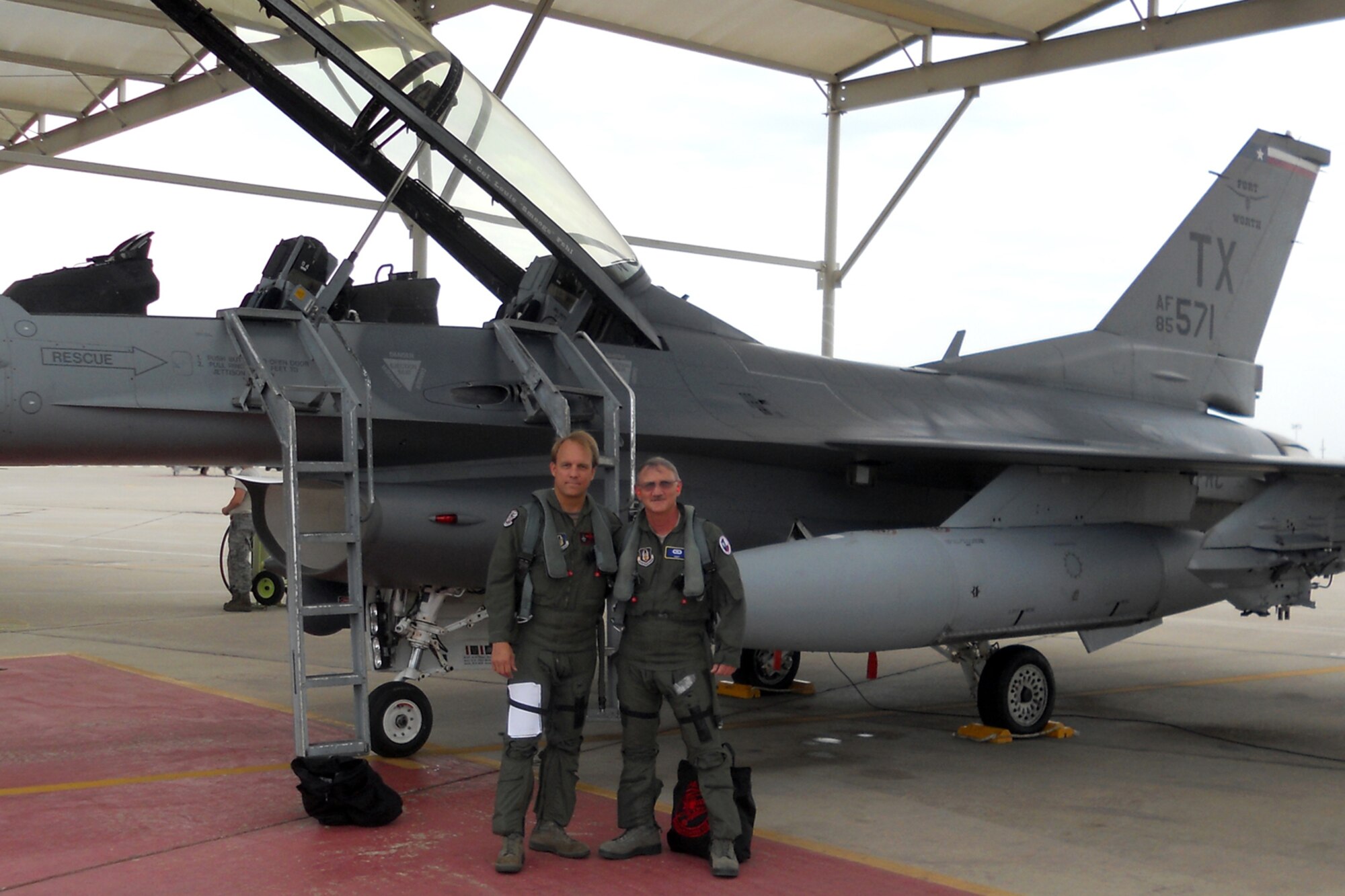 Lt. Col. David Twist, a pilot assigned to the 457th Fighter Squadron at Naval Air Station Fort Worth Joint Reserve Base, Texas, strikes a “hero pose” with Tech. Sgt. Jeff Walston in front of an F-16 Fighting Falcon before Walston’s “Incentive Flight,” July 9, 2011. Walston, a public affairs technician assigned to the 307th Bomb Wing at Barksdale Air Force Base, La., was given the ride for being the 307th Bomb Wing’s Non-Commissioned Officer of the Year for 2010. (Courtesy photo)