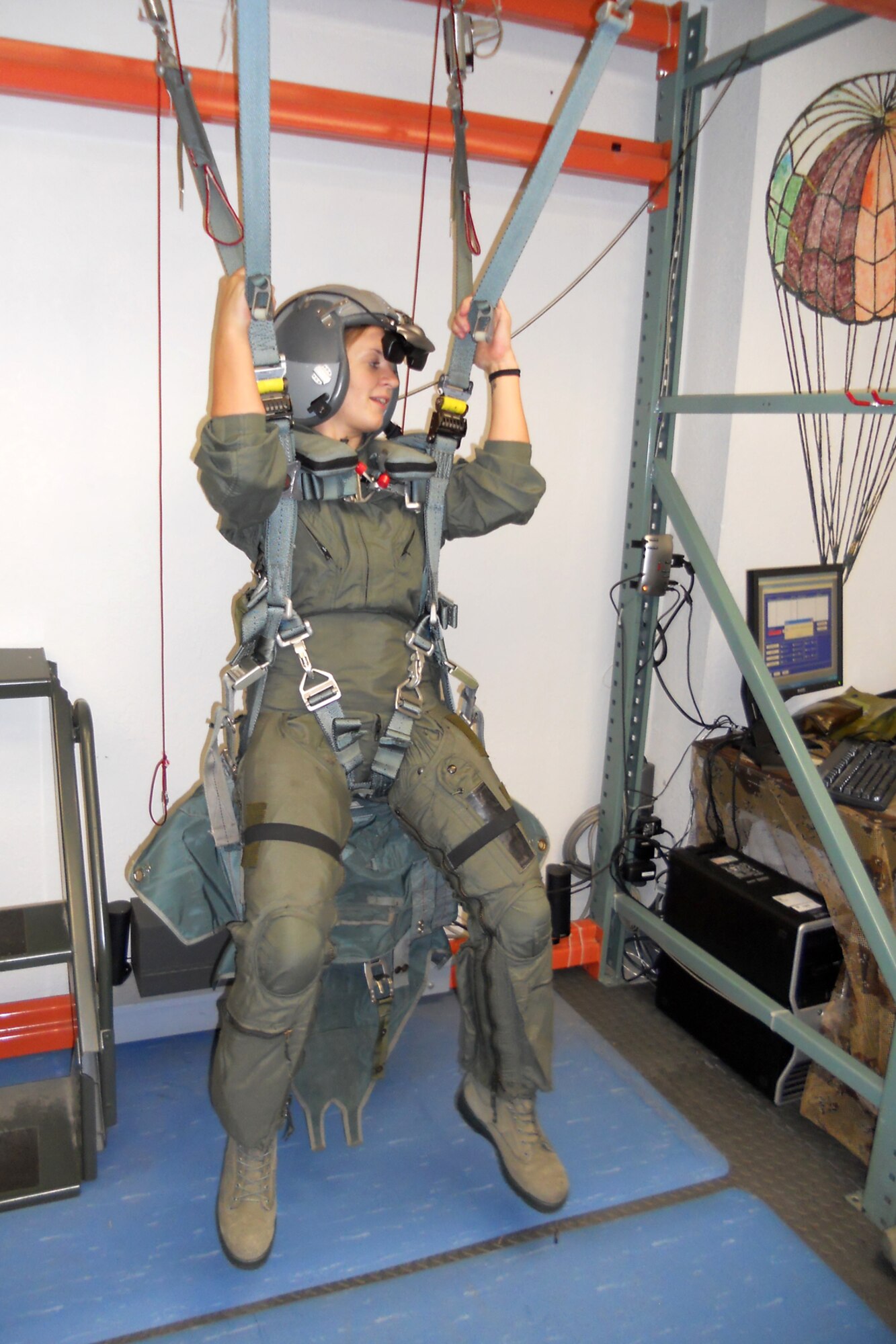Senior Airman Kimberly Simon, a flight avionics apprentice assigned to the 917th Aircraft Maintenance Squadron, at Barksdale Air Force Base, La., steers into the wind while hanging in a virtual reality parachute training system during egress training at Naval Air Station Fort Worth Joint Reserve Base, Texas, July 8, 2011. Simon, who is the 307th Bomb Wing’s Airman of the Year for 2010, was preparing for a ride on an F-16 Fighting Falcon she was given for winning the title for the 307BW. Simon’s flight was completed the next day. (Courtesy photo)