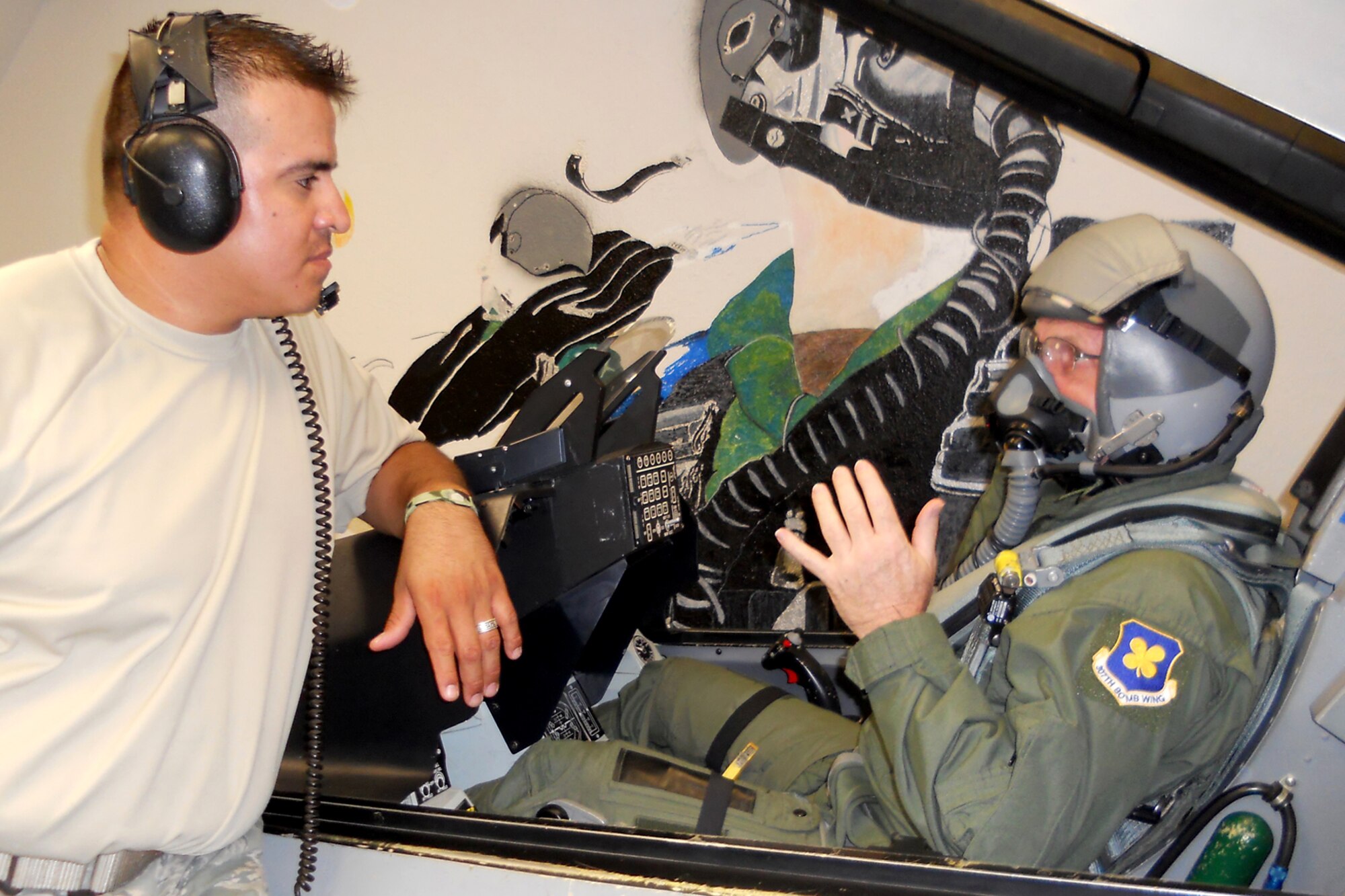 Staff Sgt. Roy Pena, an aircrew flight equipment repair technician assigned to the 301st Operations Support Flight, explains ejection procedures for the F-16 Fighting Falcon to Tech. Sgt. Jeff Walston at Naval Air Station Fort Worth Joint Reserve Base, Texas, July 8, 2011. Walston, who is a public affairs technician and the 307th Bomb Wing’s Non-Commissioned Officer of the Year for 2010, was preparing for a ride on an F-16 Fighting Falcon schedule for the next afternoon. The 307th BW is located at Barksdale Air Force Base, La. (Courtesy photo)  