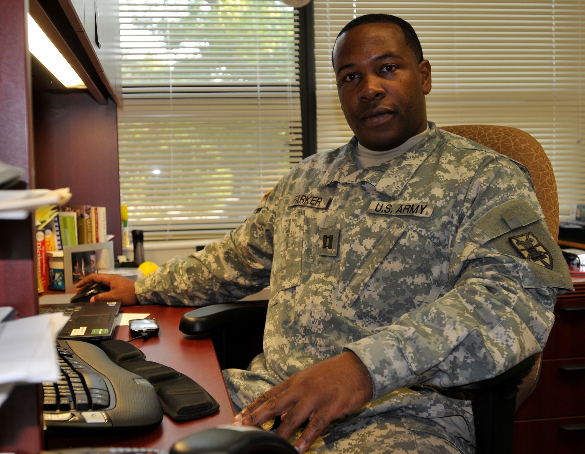 Capt. Terrence Parker, 7th Sustainment Brigade adjutant, takes a break from his demanding schedule to smile for the camera and share his favorite quote, “Remember, if you’re not encouraging, you’re discouraging.”