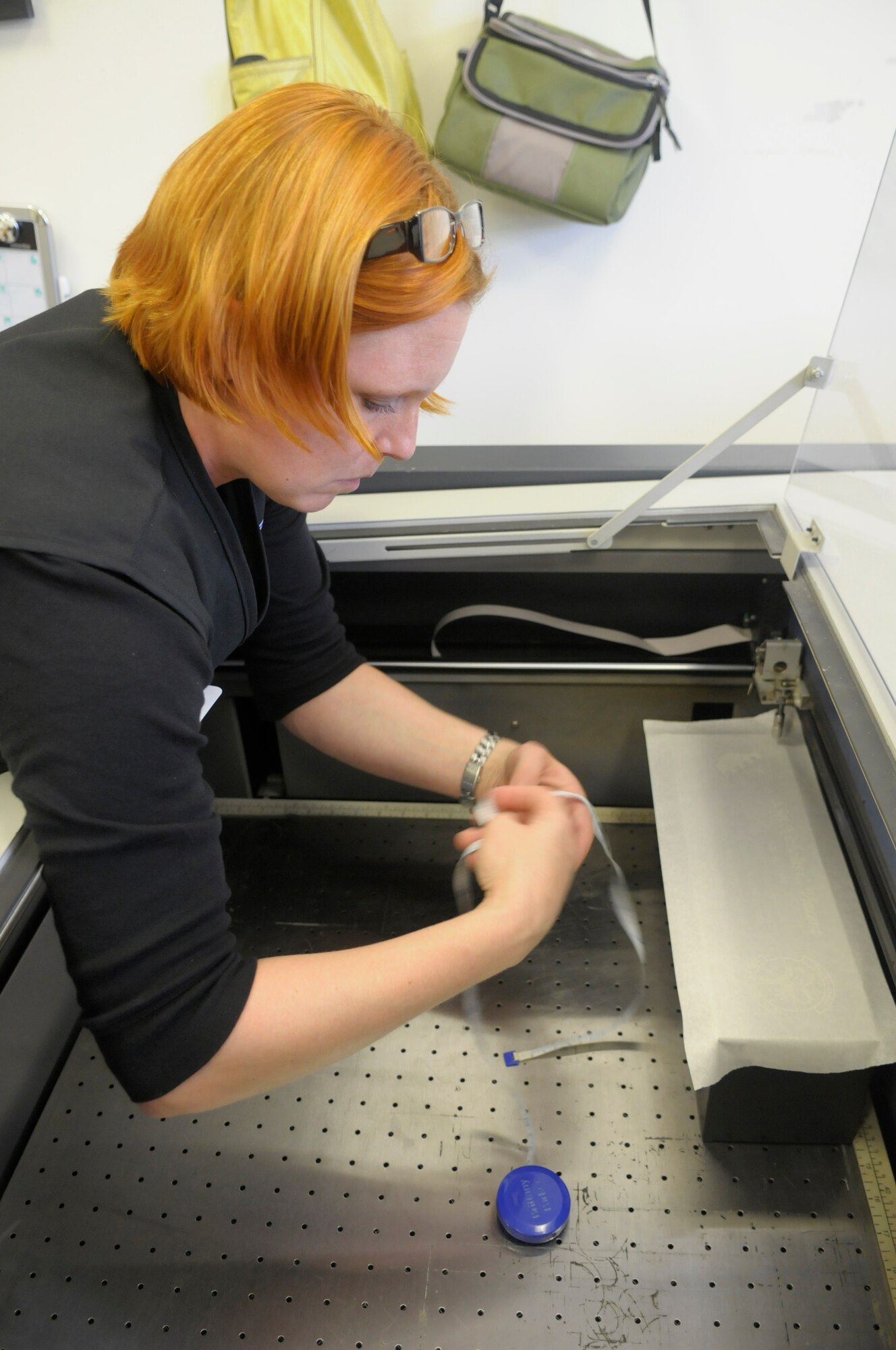 Brittany Parker, 31st Force Support Squadron Arts and Crafts Center engraver, prepares to measure the proper placement of a wine box Aug. 9 at Aviano Air Base, Italy. The Arts and Crafts center typically receives 15 to 30 orders a week for award plaques, wine boxes, glasses and various other items.  (U.S. Air Force photo/Airman Briana N. Jones)