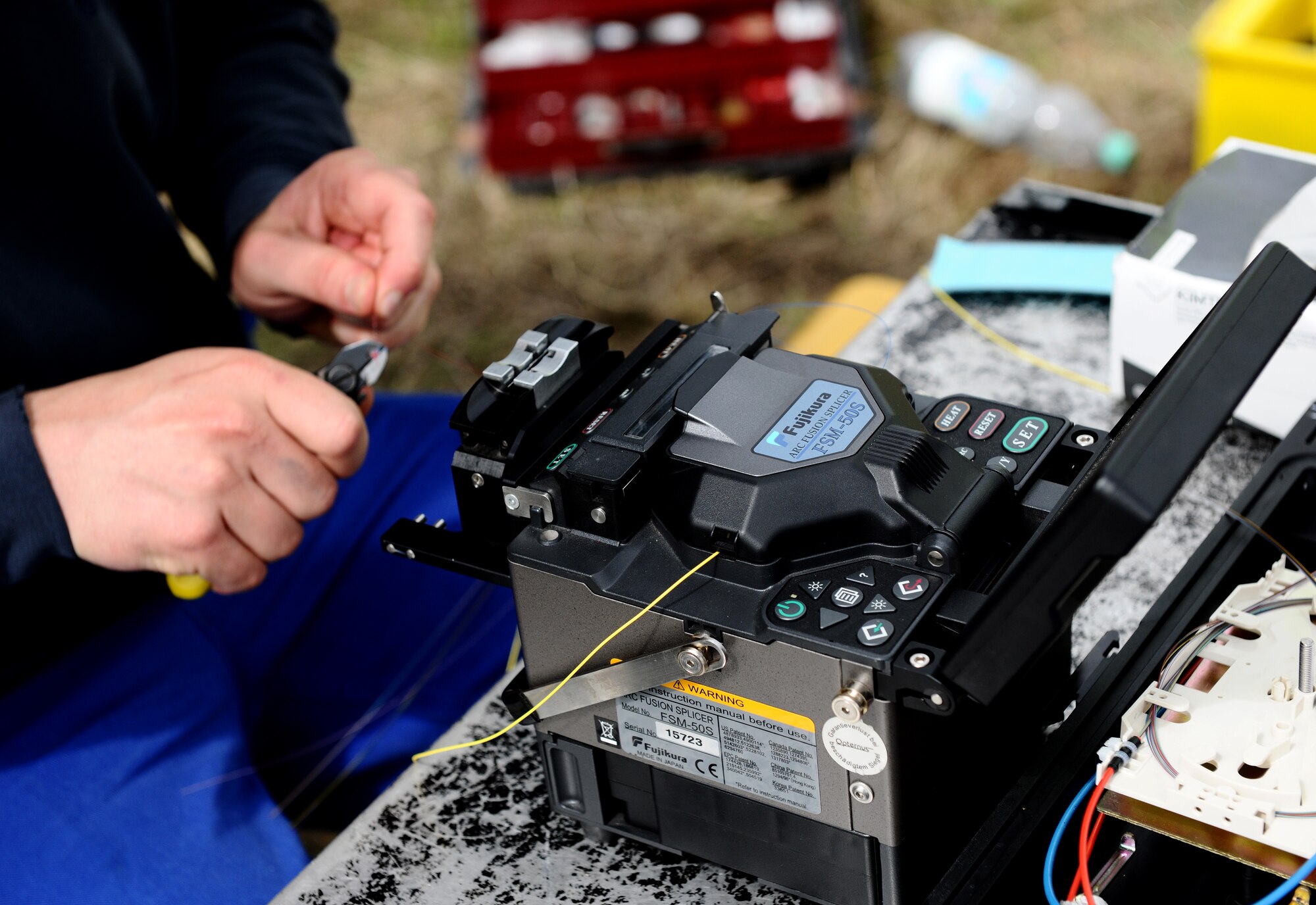 BITBURG ANNEX, Germany -- Joerg Thiel, a local contractor, prepares optical fiber cable for splicing here Aug. 11. The 52nd Communications Squadron worked with local contractors to repair a damaged optical fiber line outside Bitburg Annex, which knocked out all the annex’s DSN telephone lines. The cable maintenance technicians repaired the lines after they were inadvertently cut off base Aug. 9. (U.S. Air Force photo/Staff Sgt. Nathanael Callon)