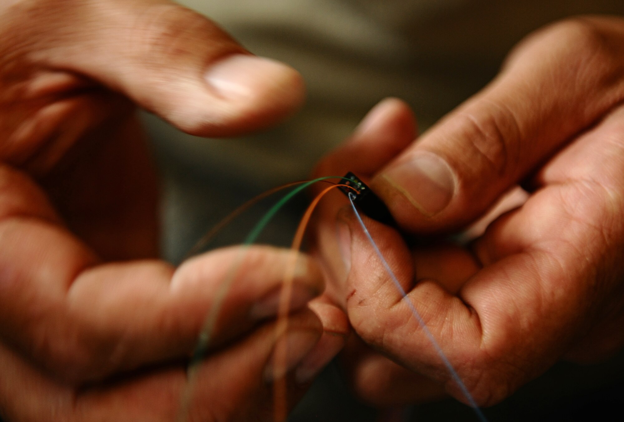 BITBURG ANNEX, Germany -- Tech. Sgt. Benjamin Reid, 52nd Communications Squadron cable maintenance NCO in charge, prepares optical fiber cable for connection here Aug. 11. The 52nd CS worked with local contractors to repair a damaged optical fiber line outside Bitburg Annex, which knocked out all the annex’s DSN telephone lines. The cable maintenance technicians repaired the lines after they were inadvertently cut off base Aug. 9. (U.S. Air Force photo/Staff Sgt. Nathanael Callon)