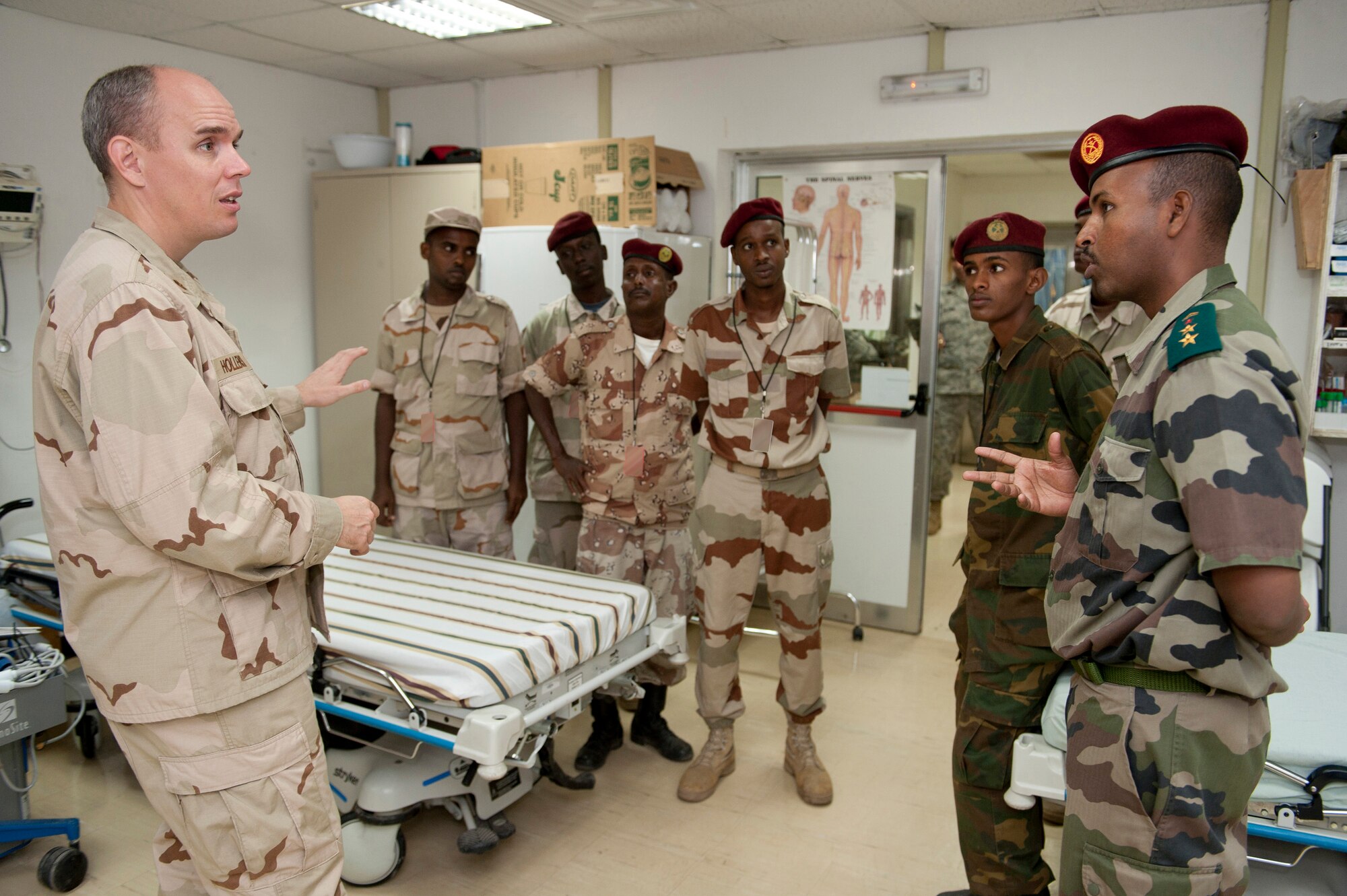 CAMP LEMONNIER, Djibouti -- (Left) Lieutenant Commander Jason Hollensbe, Camp Lemonnier Michaud Expeditionary Medical Facility general surgeon,  shows an emergency treatment room to servicemembers from the Djiboutian Military Medical Service Corps during a tour of the Expeditionary Medical Facility on Camp Lemonnier, August 9.   The tour of the facility was conducted as part of an ongoing educational partnership. (U.S. Air Force photo by Staff Sgt. Marc I. Lane)