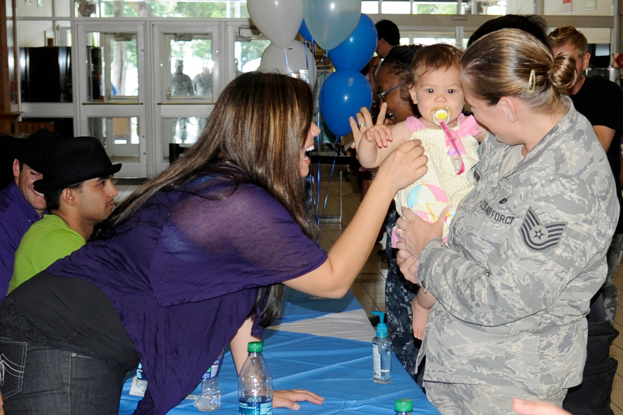 MISAWA AIR BASE, Japan -- Chelsea Sorrell, left, American Idol season 10 contestant, says "hi" to Tech. Sgt. Marie Brown, 35th Fighter Wing, and her daughter Kaylee during a "meet and greet" session at the Base Exchange Aug. 12. Eight contestants from the past two seasons of American Idol visited Misawa as part of the Armed Forces Entertainment show to sign autographs, pose for pictures and perform for military members and their families.  (photo by Dave Brown)