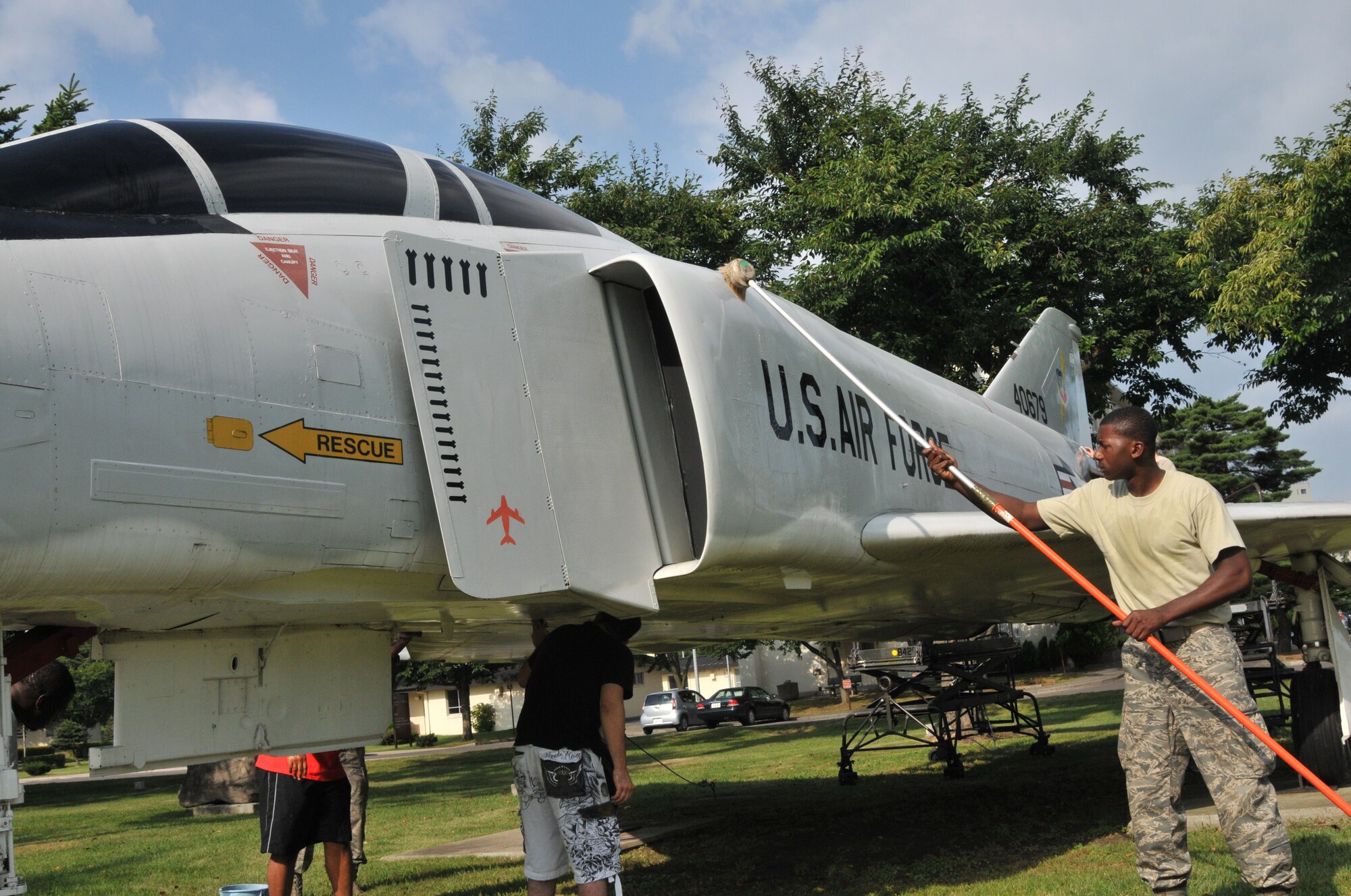 Airman First Class Dominque McFadden, 35MXS, uses a brush to scrub the side of an F-4 Phantom at Risner Circle, Misawa Air Base 12 Aug. Members of the 35 Fighter Wing volunteered to clean the two prominent aircraft displays near the wing’s headquarters building. The Phantom earned the nickname “MiG Killers” for their successful engagements against the Russian fighter jets during the Vietnam War. (U.S. Air Force Photo by Captain Darrick B. Lee/released)