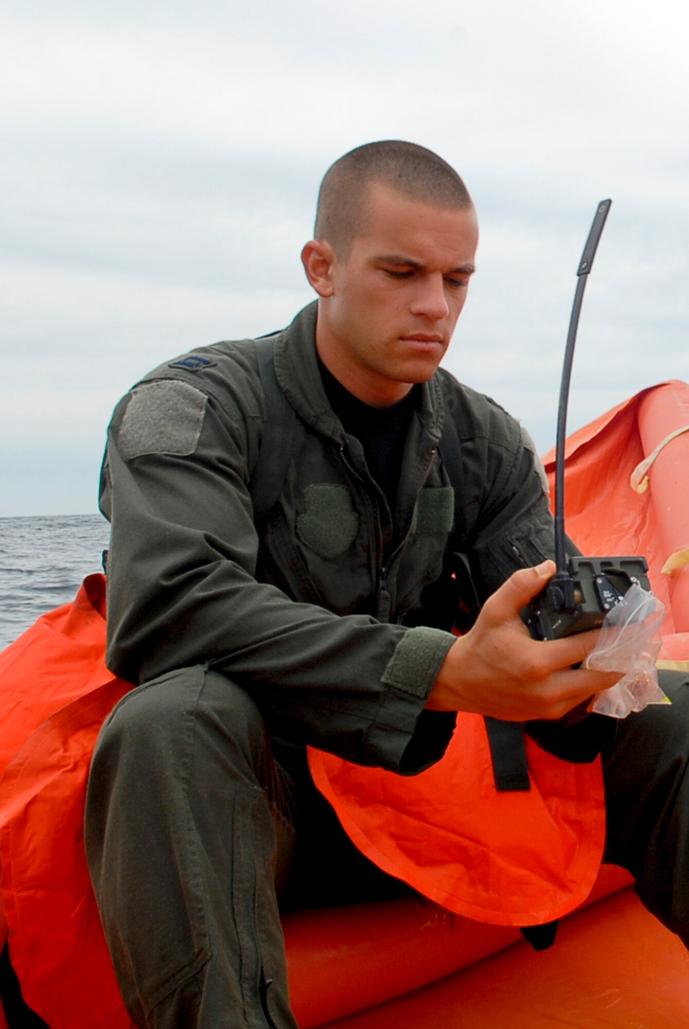 Capt. Chris Moran, 909th Air Refueling Squadron KC-135 pilot, gets a hands-on survival kit radio refresher while in a life raft during a water survival refresher course for aircrew members Aug. 11 at the Kadena Marina in Okinawa, Japan. This survival course is required every three years for aircrew members to familiarize themselves with the equipment and skills needed if they find themselves making a water landing. (U.S. Air Force photo/ Airman 1st Class Tara A. Williamson)
