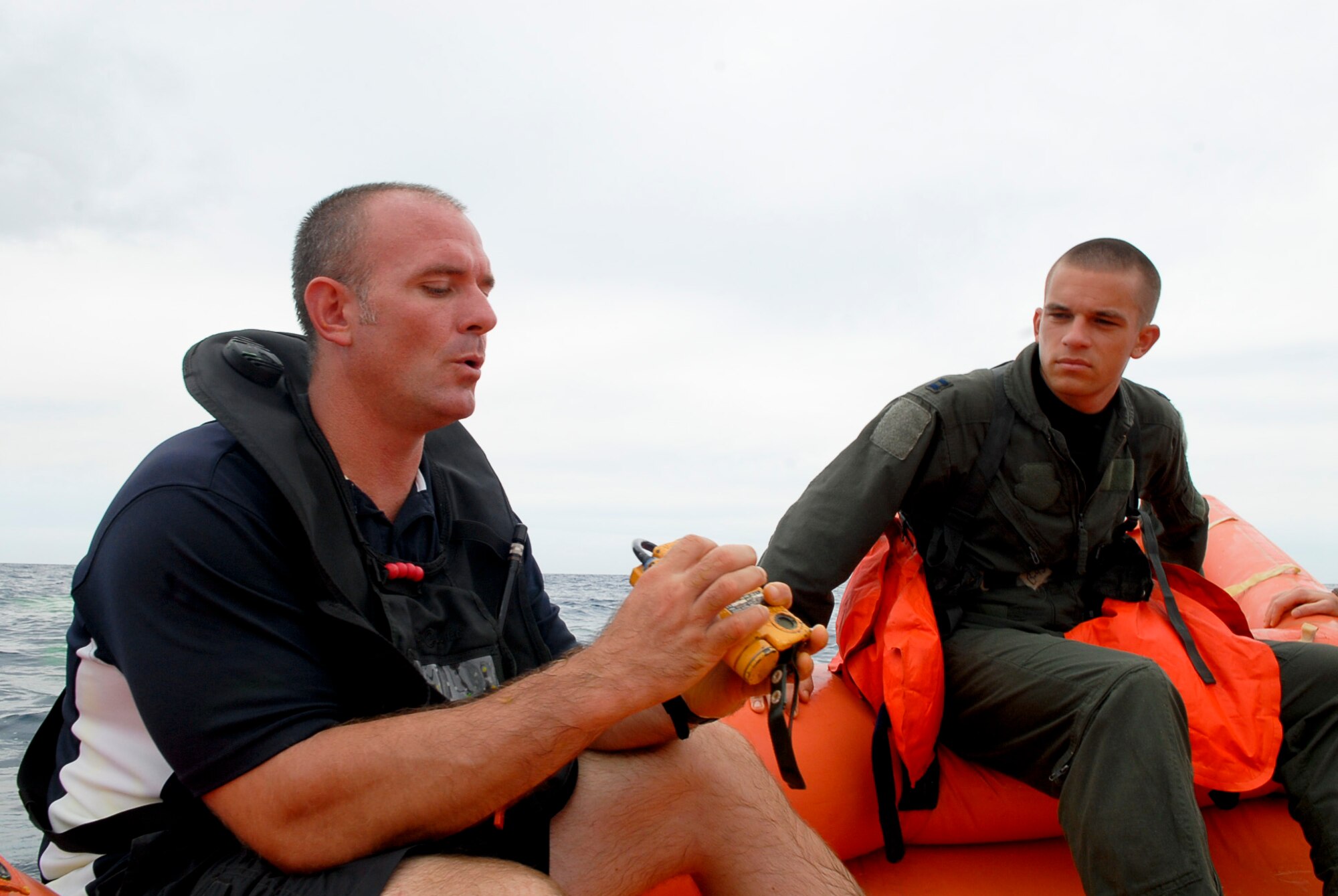 Staff Sgt. William Lambert, 18th Operations Group Survival, Evasion, Resistance, and Escape specialist, demonstrates how to operate radios found in aircraft survival kits while on a life raft during a water survival refresher course for aircrew members Aug. 11 at the Kadena Marina in Okinawa, Japan. Lambert reviewed radios, health risks, survival kit use and rescue procedures with aircrew members while in the course. (U.S. Air Force photo/ Airman 1st Class Tara A. Williamson)