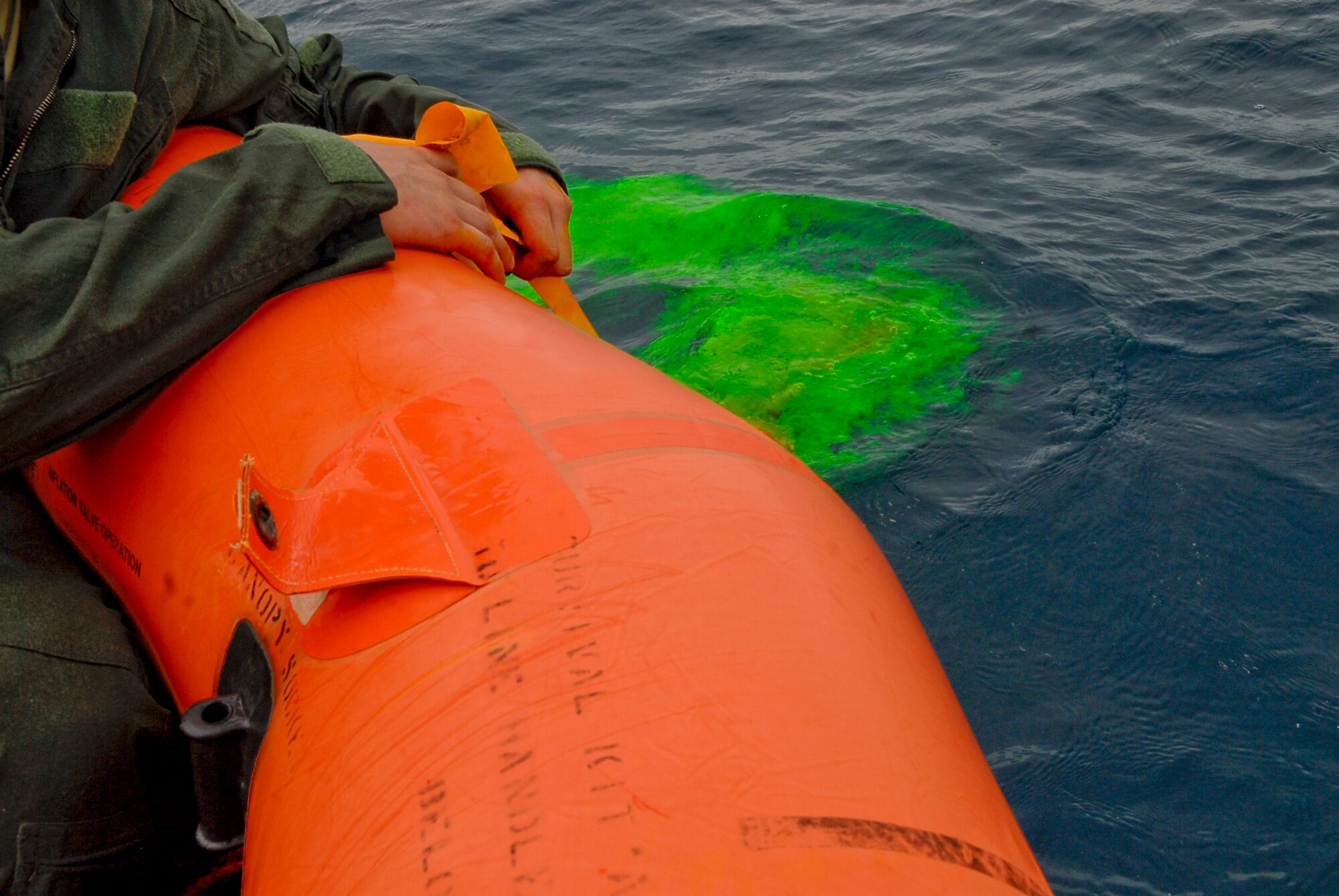 Senior Airman Dan Childress, 909th Air Refueling Squadron KC-135 boom operator, submerges a package of sea dye while in a life raft during a water survival refresher course Aug. 11 at the Kadena Marina in Okinawa, Japan. Sea dye, radios, survival techniques and health risks were topics aircrew members reviewed while taking the refresher course. (U.S. Air Force photo/ Airman 1st Class Tara A. Williamson)