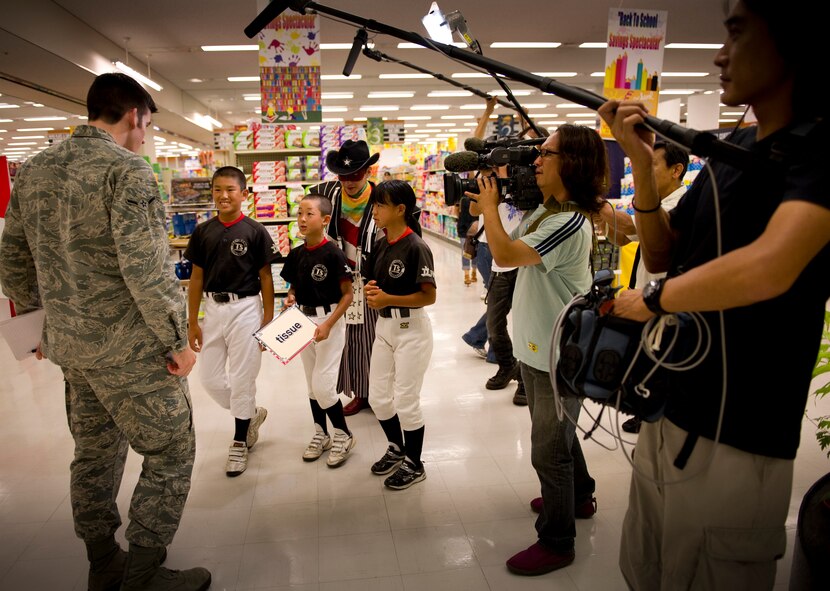 YOKOTA AIR BASE, Japan -- The Nippon Hoso Kyokai international broadcasting company visited the Commissary at Yokota Air Base, Japan to tape an episode of the Pre-Eigo, or Pre-Basic English television program, Aug. 9, 2011. The premise of the episode was to show English words of common supermarket items to approximately 15 Japanese speaking children having them looking through the commissary to find them. The children are receiving help finding tissues from Airman John Partlow, Journalist, 374th Airlift Wing Public Affairs. (U.S. Air Force photo/Staff Sgt. Stacy Moless)