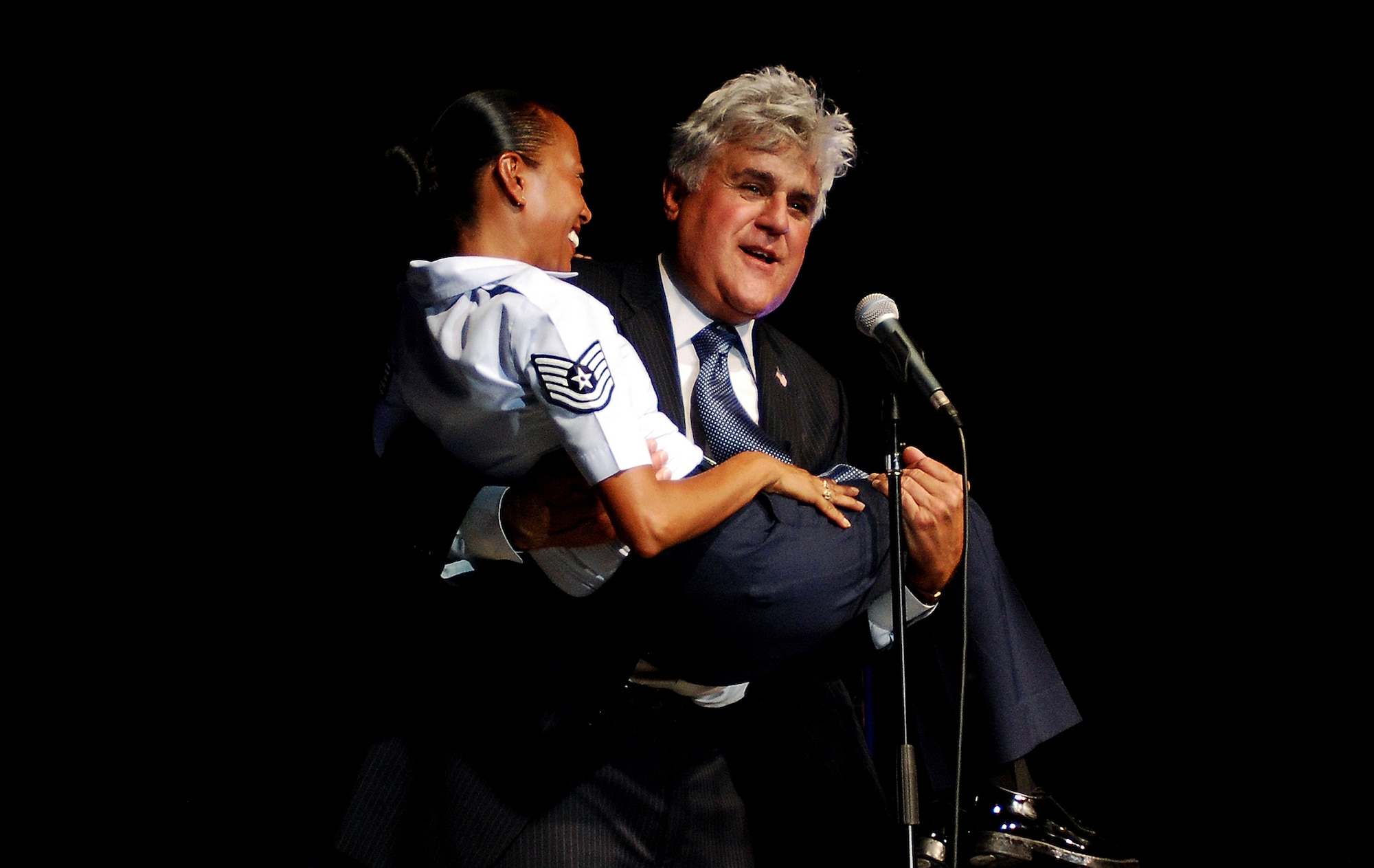 Jay Leno entertains members of the 433rd Airlift Wing, wounded warriors and their families Aug. 6, 2011 at Lackland Air Force Base, Texas. High Flight, an Air Force Reserve band, entertained the audience before Leno took the stage. The performance was part of the Refer a Friend Tour, which was to thank the Airmen who participated and educate other about the benefits of the Get 1 Program.  (U.S. Air Force photo/Senior Airman Brian McGloin)