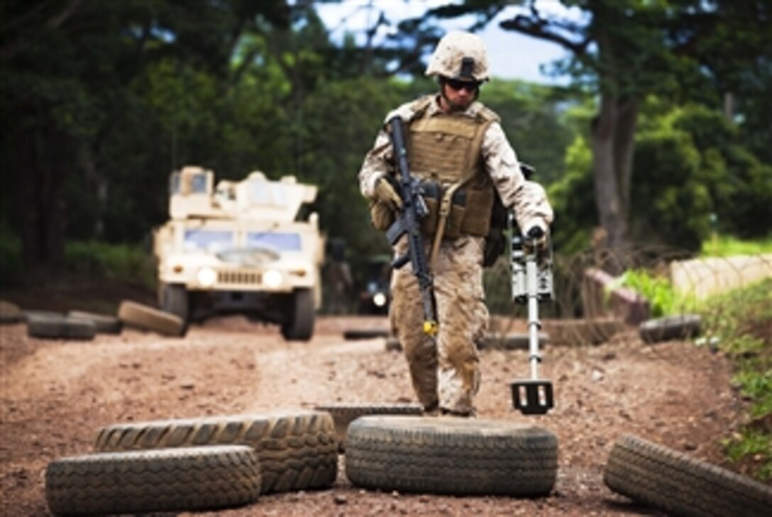 U.S. Marine Corps Lance Cpl. David Engel, an anti-tank missileman with Weapons Company, 3rd Battalion, 3rd Marine Regiment, uses a mine detector to sweep for mock improvised explosive devices during counterinsurgency training at Schofield Barracks, Hawaii, on Aug. 2, 2011.  