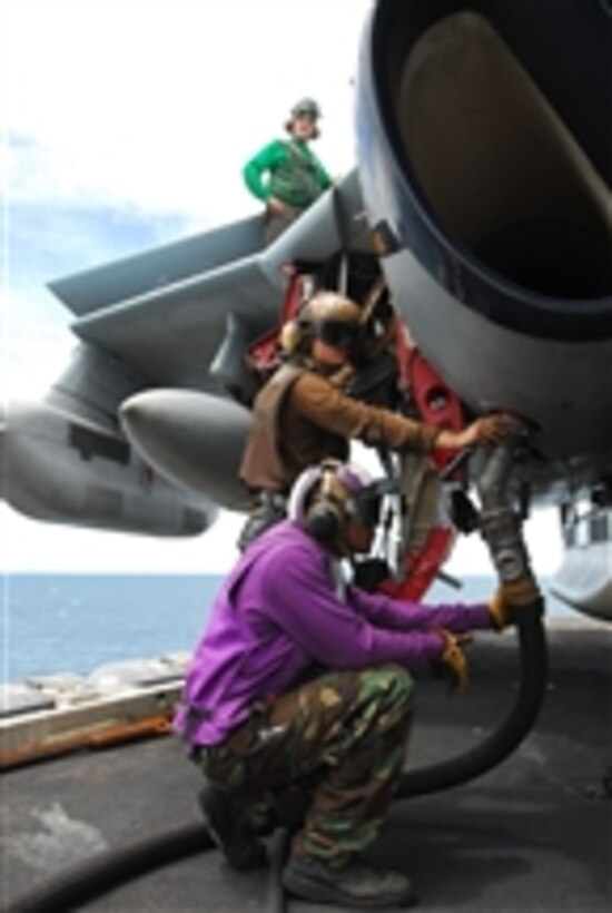 Airman Raymond Burrell and Airman Thomas Robertson fuel an EA-6B Prowler assigned to Electronic Attack Squadron 136 aboard the nuclear-powered aircraft carrier USS George Washington (CVN 73) in the Gulf of Thailand on Aug. 11, 2011.  The George Washington departed its forward-operating base of Fleet Activities Yokosuka to patrol the U.S. 7th Fleet area of responsibility.  