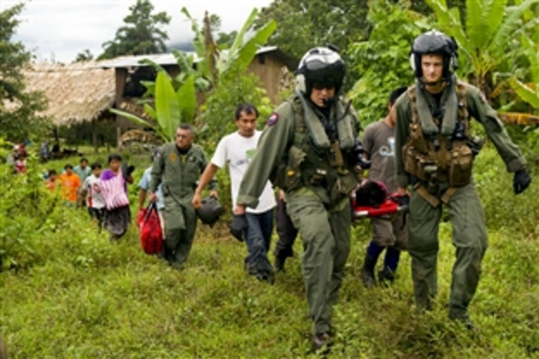 U.S. Navy Chief Justin Crowe, left, and Petty Officer 3rd Class Joe Wainscott and villagers carry an injured boy toward an MH-60S Seahawk helicopter during Continuing Promise 2011 in Bajo Blay, Costa Rica, Aug. 10, 2011. Crowe and Wainscott are assigned to Helicopter Sea Combat Squadron 26. Continuing Promise is a five-month humanitarian assistance mission to the Caribbean, Central and South America.