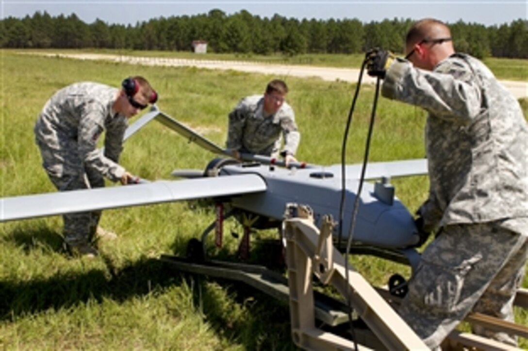 Army soldiers mount a Shadow 200 unmanned aerial vehicle onto its launching catapult for a training flight on Fort Bragg, N.C., Aug. 10, 2011. The catapult launches the 400-pound UAV in fewer than 40 feet.