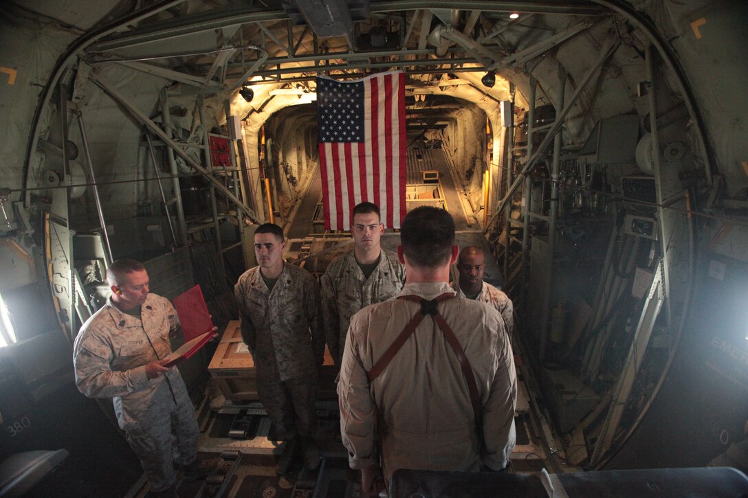 Sgt. Marc Longoria, center-left, Cpl. Michael Prince and Cpl. Shawn Rose, reenlisted aboard a KC-130J Hercules in the skies of Afghanistan, Aug. 13. Longoria, a native of Yuma, Ariz., and Prince, of Battle Creek, Mich., both serve as powerline mechanics with Marine Attack Squadron 513. Rose, of Freeport, N.Y., serves the squadron as an avionics technician.