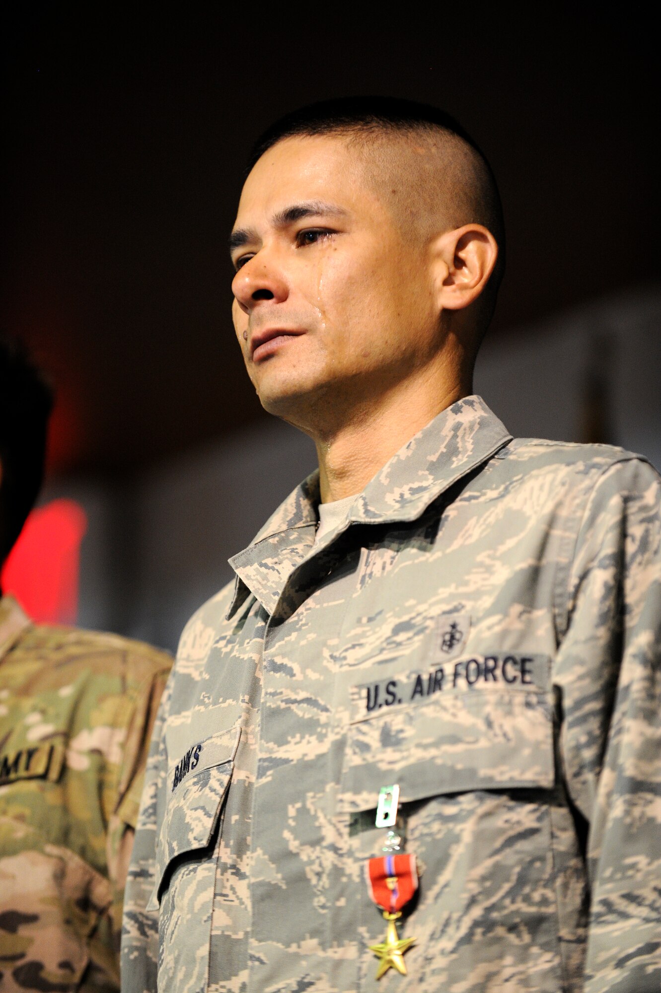 U.S. Air Force Master Sgt. Christopher Banks, a ground medic from the 438th Air Expeditionary Wing, stands at attention after the presentation of the Bronze Star with Valor at Kabul International Airport, Kabul, Afghanistan, August 13, 2011.  Banks was awarded the Bronze Star for actions taken in the line of fire April 27, 2011.  (U.S. Air Force photo by Staff Sgt. Matt Smith)