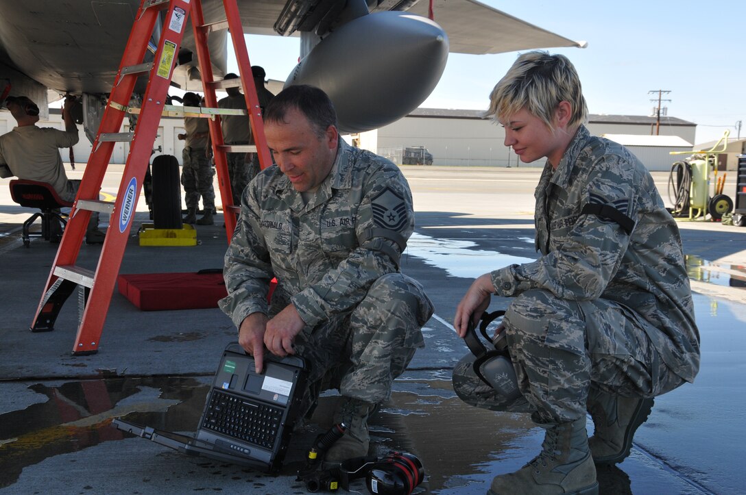 Master Sgt. Tom MacDonald, and Staff Sgt. Celeste Walsh review the procedure before preforming an inspection of the emergency escape system on the F-15D Eagle. Both MacDonald and Walsh are deployed with 104th Fighter Wing, Massachusetts Air National Guard, to Joint Base Elmendorf-Richardson, Alaska supporting a joint training exercise. (U.S. Air Force Photo by: Technical Sergeant, Anthony Mutti)