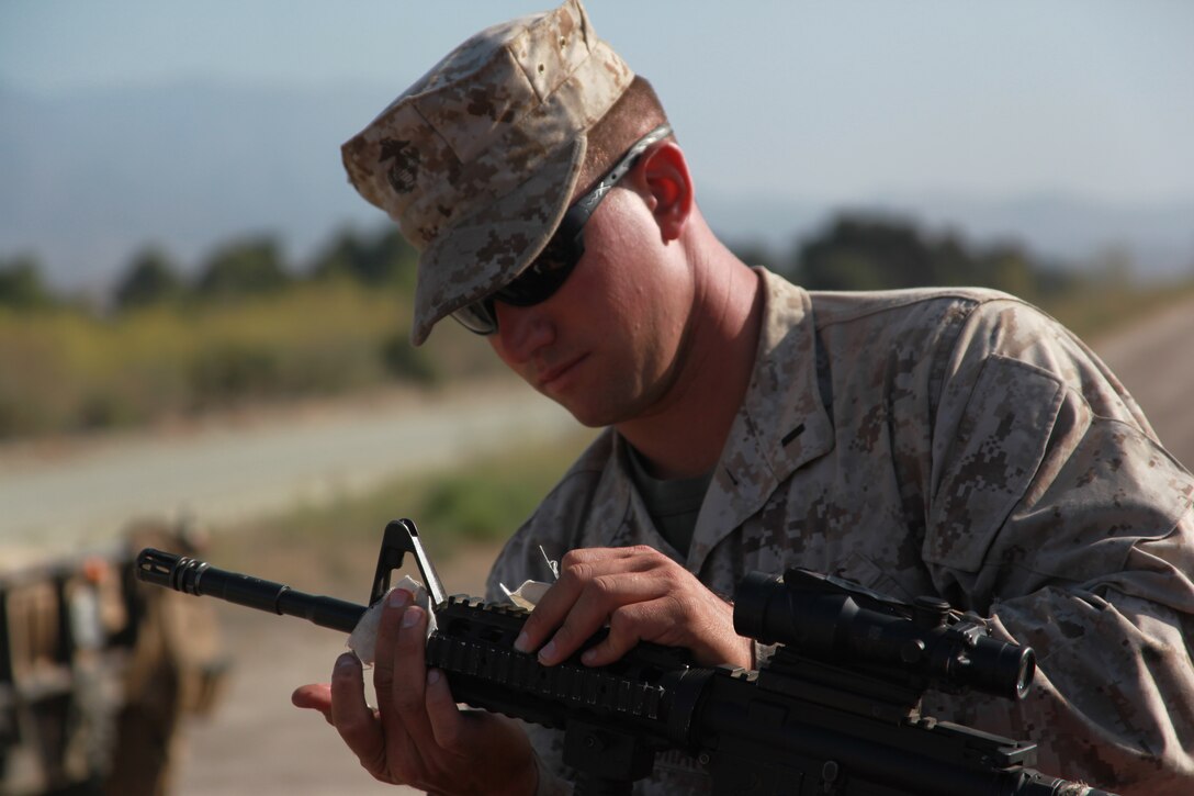First Lt. Jerad E. Bermingham cleans his rifle before combat::r::::n::marksmanship training here Aug. 14. Bermingham, 26, is the::r::::n::officer-in-charge of Combat Logistics Battalion 11's engineer::r::::n::detachment and a Stephenville, Mich., native. The battalion provides logisitics and services to the 11th Marine Expeditionary Unit,::r::::n::scheduled to deploy this fall.