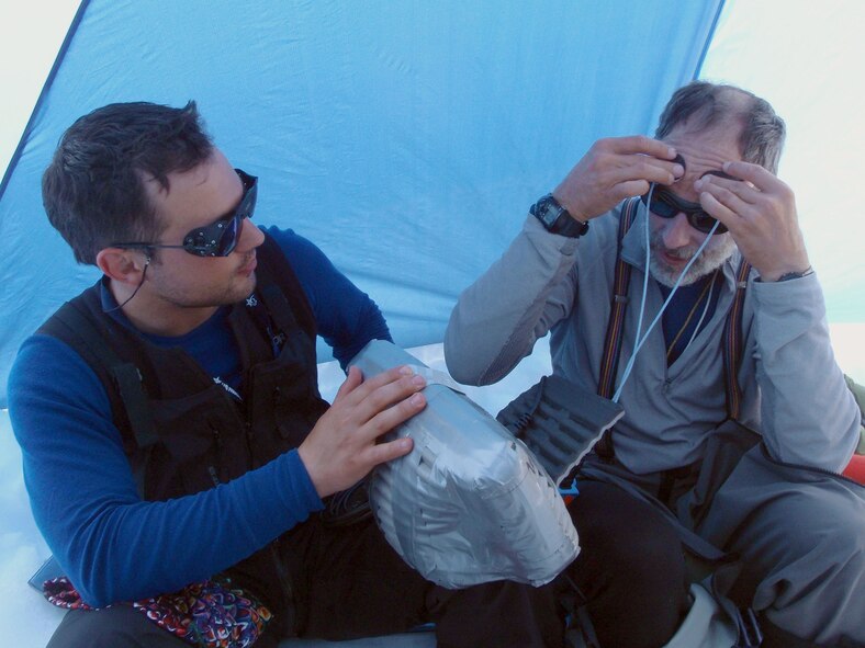 MOUNT MCKINLEY, Alaska -- Tech. Sgt. Jeremy Madama, a pararescueman from the 212th Rescue Squadron, assists fellow climber Gerard Coleman with medical equipment on the Combat Wounded Warrior Denali expedition June 28. Members of the squadron supported a three-week, grassroots wounded-warrior project to take injured veterans up Mount McKinley starting Jun 23.