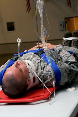 Airman 1st Class Jason McNew, 2nd Maintenance Squadron, is strapped down on a stretcher during the "Street Smart" safety presentation held at Hoban Hall on Barksdale Air Force Base, La., August 12. This was part of a demonstration to show the audience the different procedures firefighters/paramedics may have to perform to save a life following a car crash. More than 800 Team Barksdale members showed up for the presentation. (U.S. Air Force photo/Senior Airman La'Shanette V. Garrett) (RELEASED)