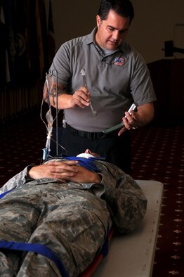 Joseph H. McCluan, firefighter paramedic from Orlando, Fla., demonstrates a procedure on Airman 1st Class Jason McNew, 2nd Maintenance Squadron, during the "Street Smart" safety presentation at Hoban Hall on Barksdale Air Force Base, La., August 12. The program aims to take the audience into real life drama experienced by firefighters/paramedics as they work to save lives of individuals who have made poor choices when it comes to drinking and driving, using drugs and not wearing seatbelts. (U.S. Air Force photo/Senior Airman La'Shanette V. Garrett) (RELEASED)