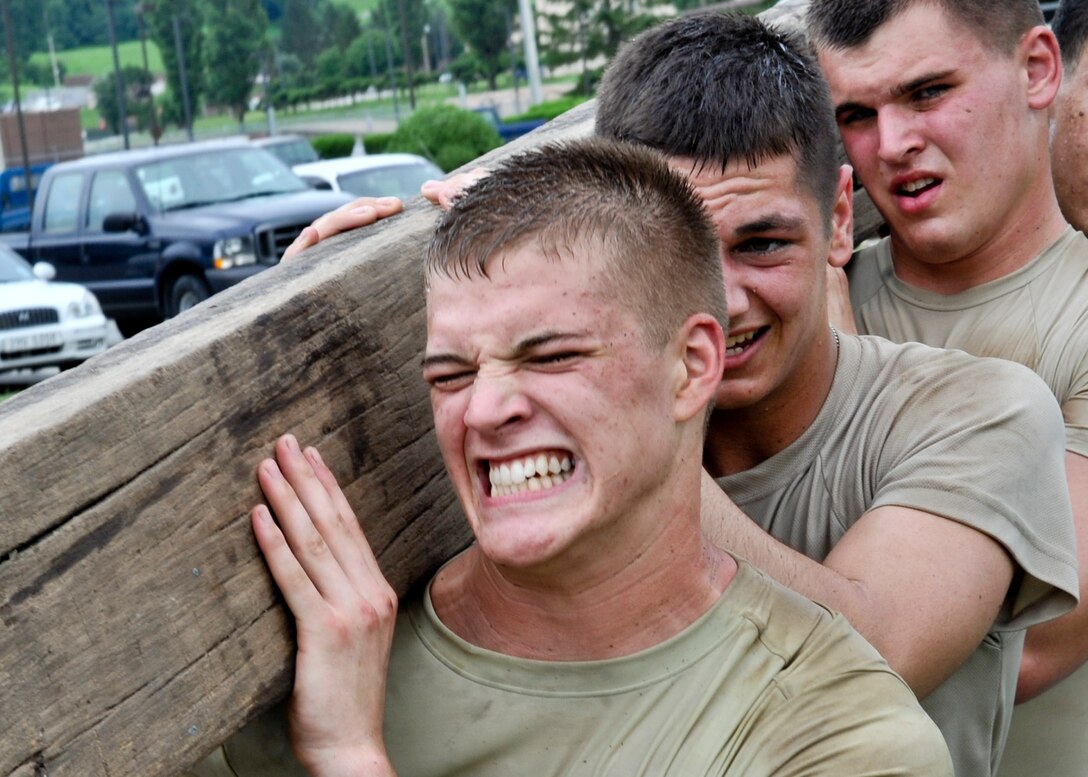 A squad of Airmen from the 51st Security Forces Squadron at Osan Air Base, South Korea, who are attempting to qualify for the base’s quick response team, secure a 100-pound wooden beam on their shoulders as they complete a 5K march Aug. 9, 2011.  To become a member of the base’s QRT, Airmen have to overcome challenges which test their strength and endurance, but also test their ability to act as a cohesive squad. (U.S. Air Force photo/ Senior Airman Adam Grant)