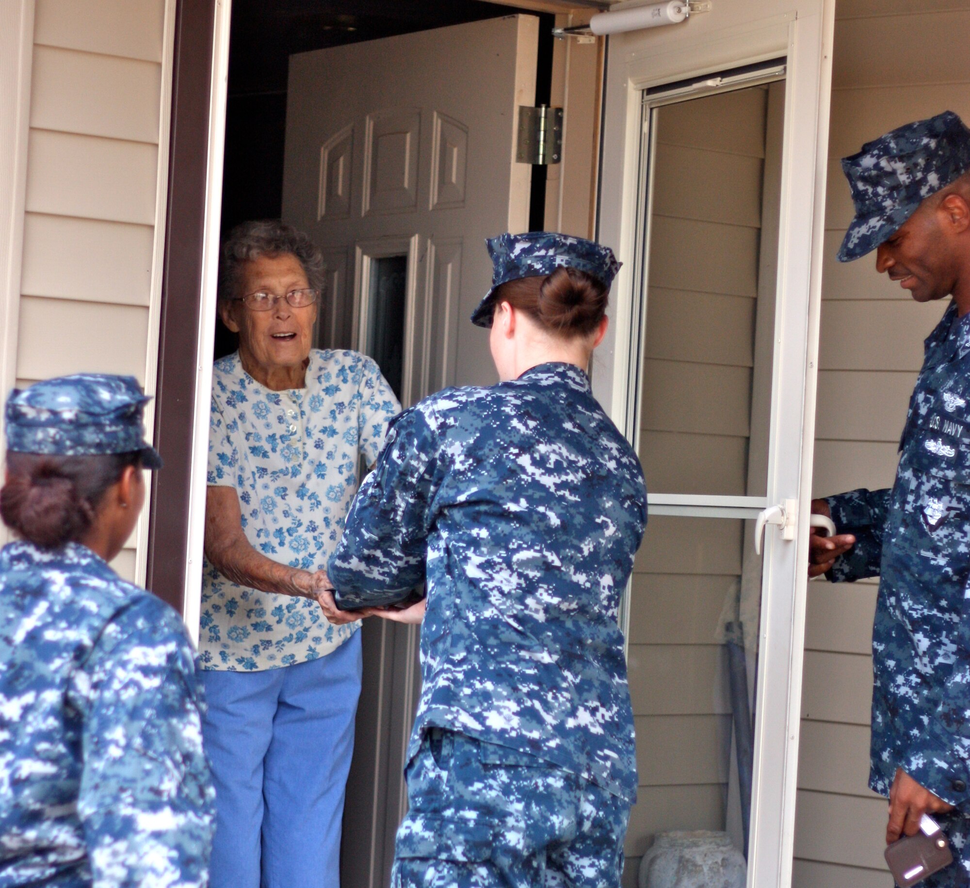 SAN ANGELO, Texas -- Merlie Smith, one of the Meals for the Elderly participants, receives her food from volunteer Navy Petty Officer 3rd Class Stephanie Hauge Aug. 12. (Courtesy photo/Whitney Haskell)