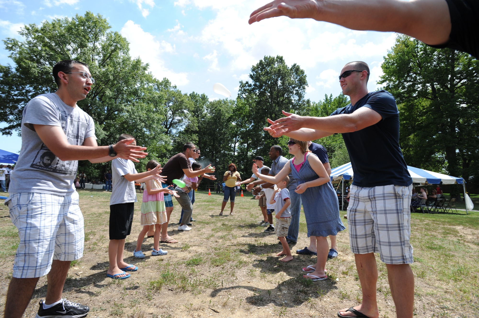 Air Force District of Washington members and their families participate in a balloon throwing contest during the AFDW Family Day on Joint Base Andrews, Md. Aug. 12. The contest was won by Capt. Paul Babiarz and his son Paul. (U.S. Air Force photo by Staff Sgt. Christopher Ruano)