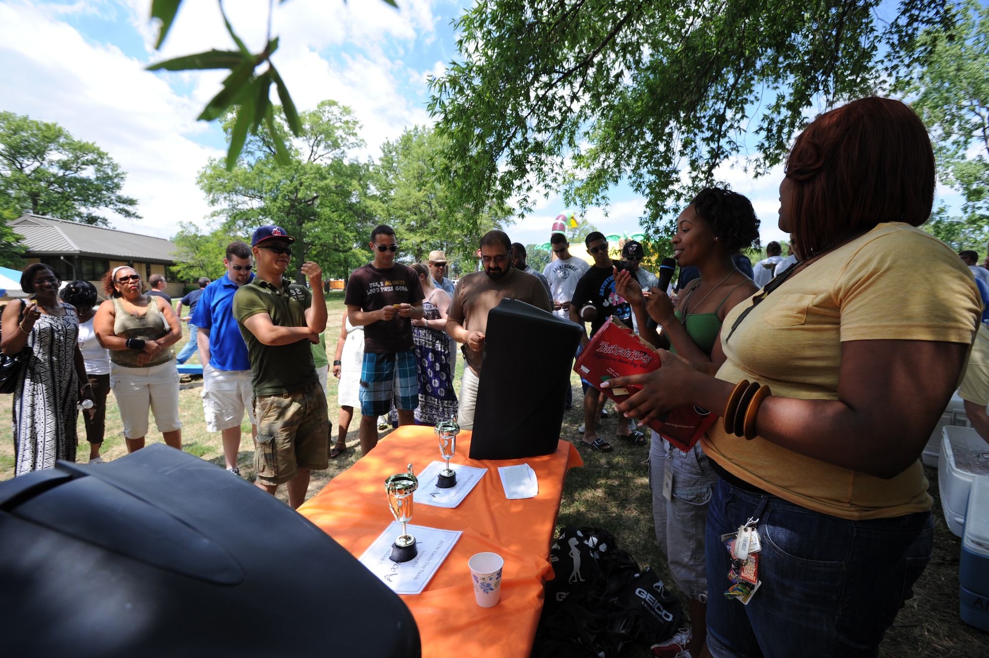Rasean Booker, Air Force District of Washington administrative assistant, announces the winning number during the AFDW Family Day on Joint Base Andrews, Md. Aug. 12. Prizes included goodie bags, and pizza gift cards. (U.S. Air Force photo by Staff Sgt. Christopher Ruano)