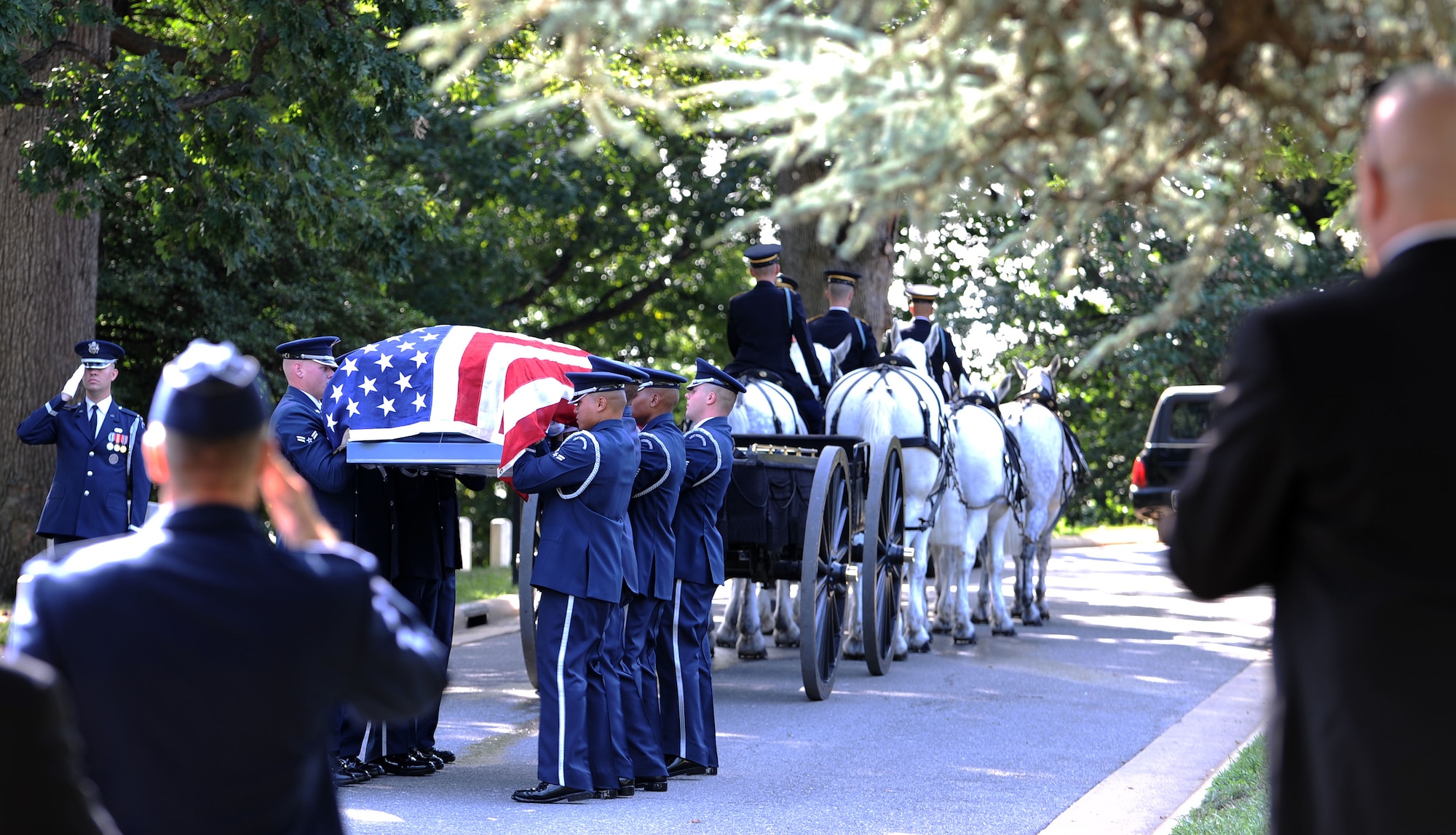 Members of the Air Force Honor Guard prepare to position the casket of retired Col. John Carey in its final resting place at Arlington National Cemetery Aug. 12, 2011. Carey, a veteran with more than 30 years of service to his country, received full military honors during the service including an F-15E Strike Eagle missing man flyby. (U.S. Air Force photo/Staff Sgt. Tiffany Trojca)