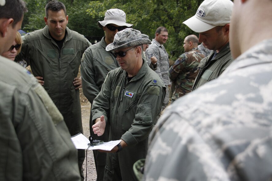 Lt. Col. Randall D. Johns, instructs his team on how to use a lensatic compass for land navigation during a field training exercise on combat survival training for the 911th Operations Group air crew members during the August unit training assembly.(U.S. Air Force photo/Senior Airman Jonathan Hehnly)