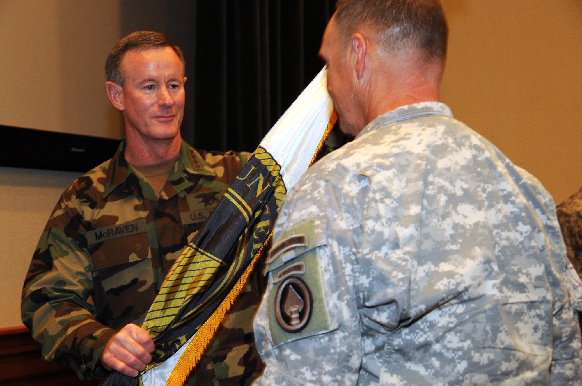 Adm. William H. McRaven passes the U.S. Special Operations Command flag to Command Sgt. Major Thomas Smith. McRaven assumed command of USSOCOM from Adm. Eric T. Olson during a ceremony at the Davis Conference Center, MacDill Air Force, Fla., Aug. 8. (US Special Operations Command photo by Mike Bottoms) 