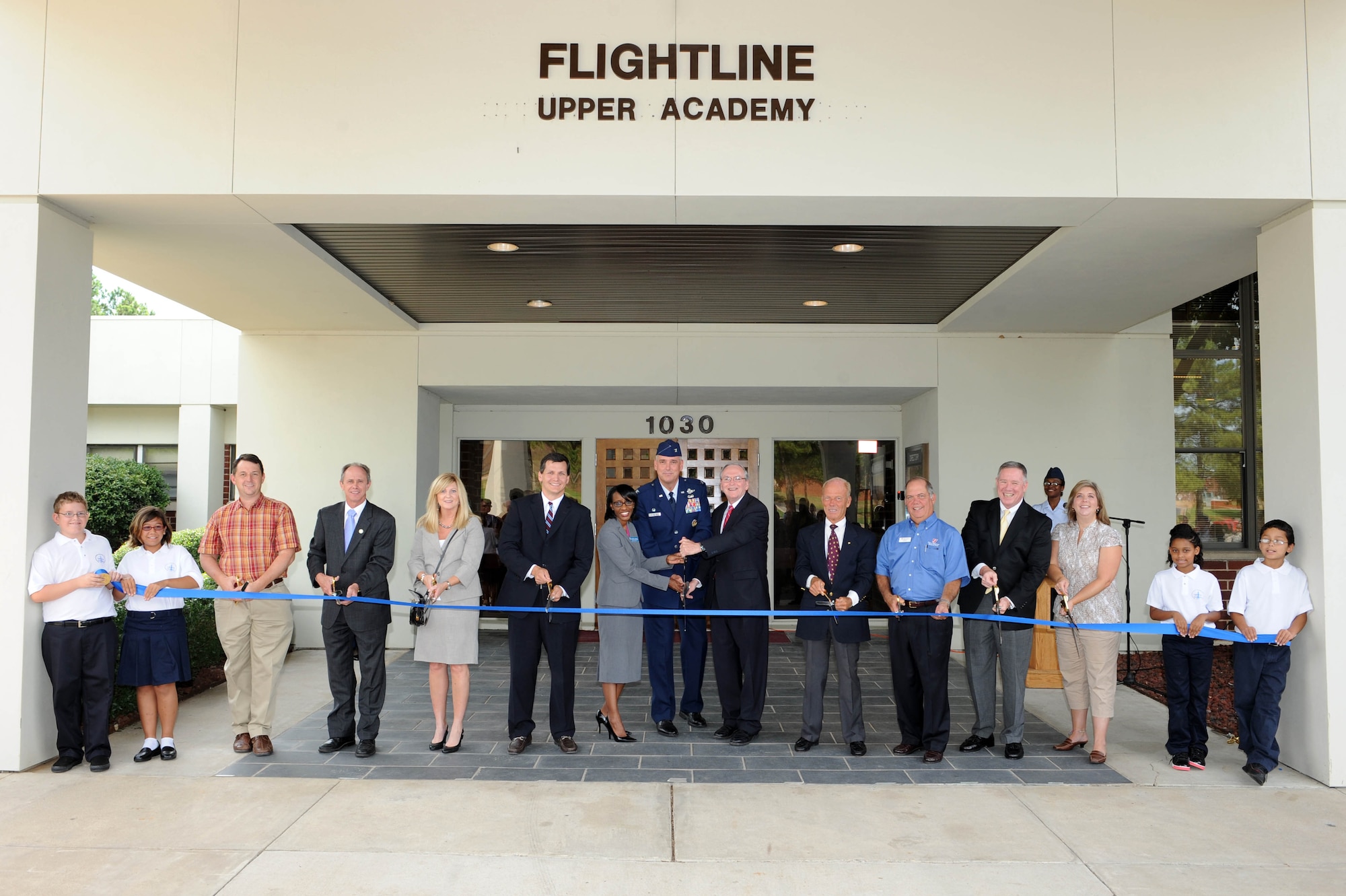Jody Urquhart (third from left), Jacksonville Chamber of Commerce representative; Jacksonville Mayor Gary Fletcher; Mary Ann Duncan, charter school office director; Greg Ehrhardt, Hunt Development Group representative; Dr. Phillis Nichols Anderson, Southern Region vice president; Col. Mike Minihan,19th Airlift Wing commander; Mike Ronan, Lighthouse Academies president; Mike Wilson, donor and Wilson Family Foundation representative; Larry Wilson, donor and Wilson Family Foundation representative; Mike Rooan, Pinnacle representative; and Keri Urquhart, Lighthouse Academies of Arkansas board director, cut the ceremonial ribbon of the new Jacksonville Lighthouse Charter School Flightline Upper Academy with Payton Fraley, Ray Anna Jordan, Sincere Yellowbird and Monta Ehrcke on Aug. 15, 2011, at Little Rock Air Force Base, Ark. The school will provide a college preparatory education through enriched and advanced course offerings focused on the needs of low-income and transient student population, and provide a meaningful competitive choice of education opportunities for families. (U.S. Air Force photo by Staff Sgt. Jim Araos)
