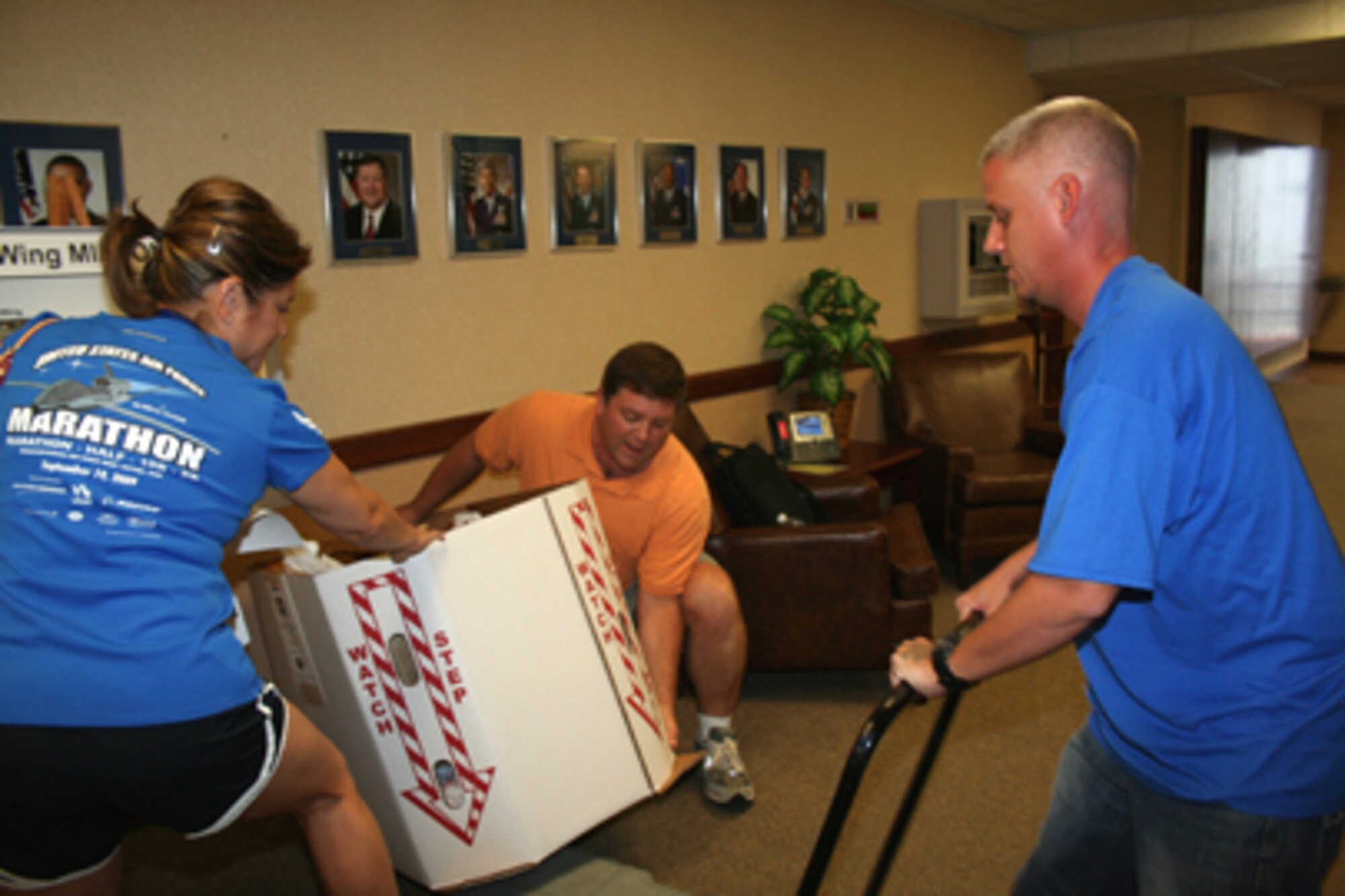 Alamo Federal Executive Board executive director Ellen Nelson, her assistant Bruce Bebow (center) and Defense Civilian Personnel Advisory Service employee Andrew Pruett collect food and sundries donated by Air Force Personnel Center Airmen for delivery to the San Antonio Food Bank in support of the Feds Feed Families summer food drive. AFPC donated 543 pounds of food the first month of the drive. (U.S. Air Force photo/Debbie Gildea)