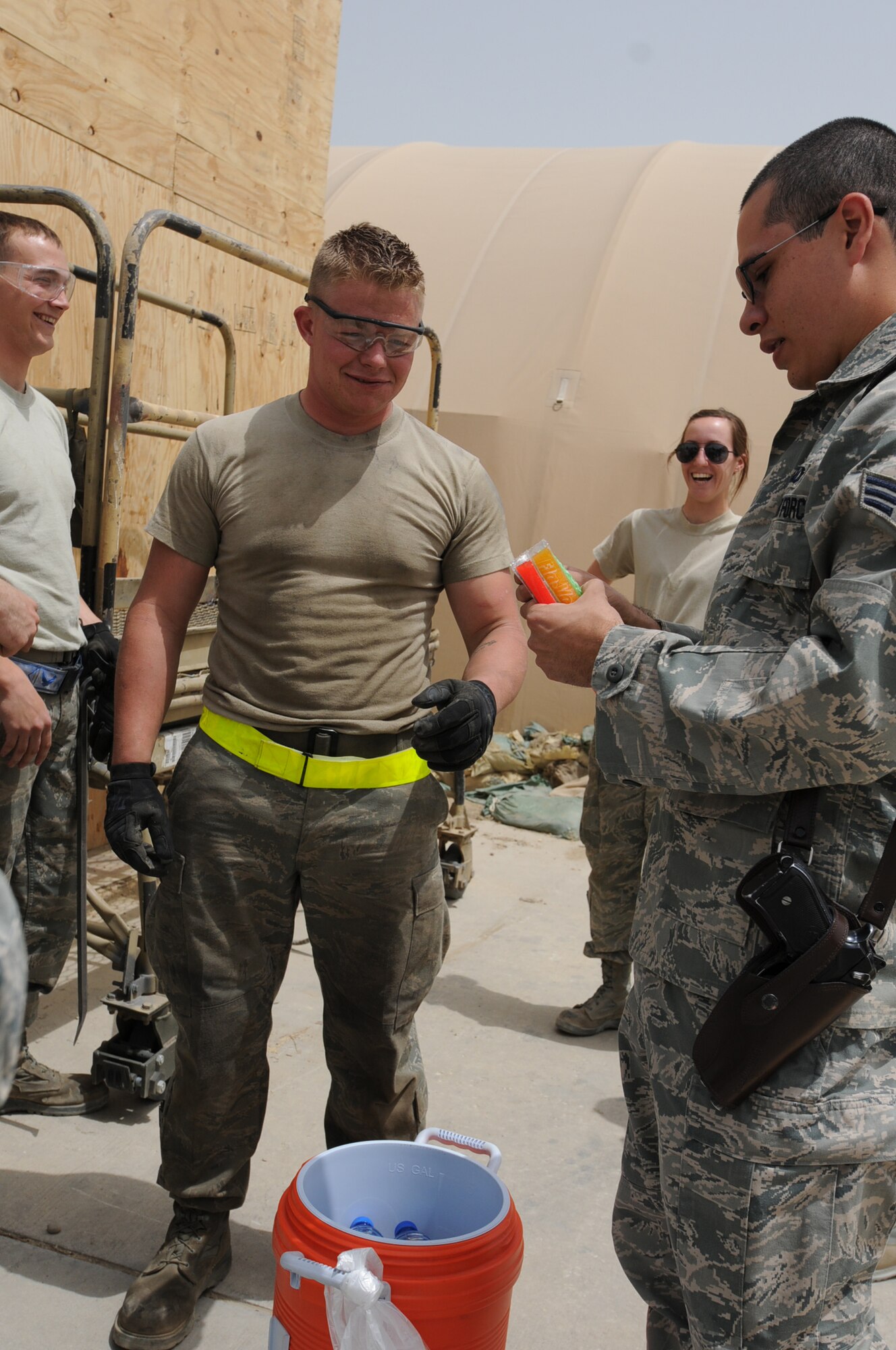 With ice popsicles in hand, Senior Airman Hansel Orozco, 455th  Air  Expeditionary Wing  chaplain assistant, helps  provides fellow deployed Airmen much-needed relief from the heat, while spreading the word about the flightline Religious Support Team's ministry on Bagram Airfield's east side, July 15, 2011, at Bagram Air Field, Afghanistan. Airman Orozco is assigned to the 433rd Airlift Wing (stateside) at Lackland Air Force Base, Texas, where he serves as a chaplain assistant. His Hometown is San Antonio and he attended Oliver Wendell Holmes High School. (U.S. Air Force photo/Senior Airman Krista Rose)