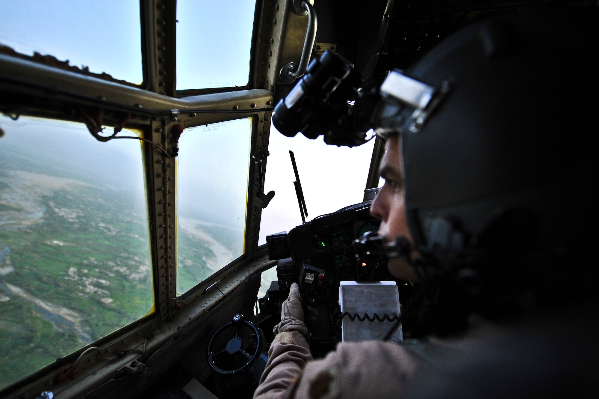 Maj. Stephen Cheek, 746th Expeditionary Airlift Squadron aircraft commander, checks the terrain from the cockpit of a C-130 Hercules during an aeromedical evacuation flight, Aug 7.  Cheek hails from Southern Pines, N.C., and is deployed from Pope Field, N.C. (U.S. Air Force photo/Senior Airman Paul Labbe)
