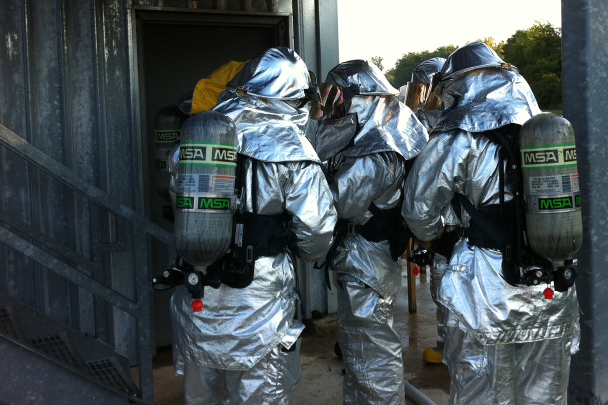 Firefighters with the 307th Civil Engineering Squadron prepare to enter a fire training facility room at Barksdale Air Force Base, La., Aug. 6, 2011. The room was intentionally set ablaze so the firefighters could engage in live fire structural training.  The annual exercise was designed to provide training on putting out commercial and residential fires. (Courtesy photo)