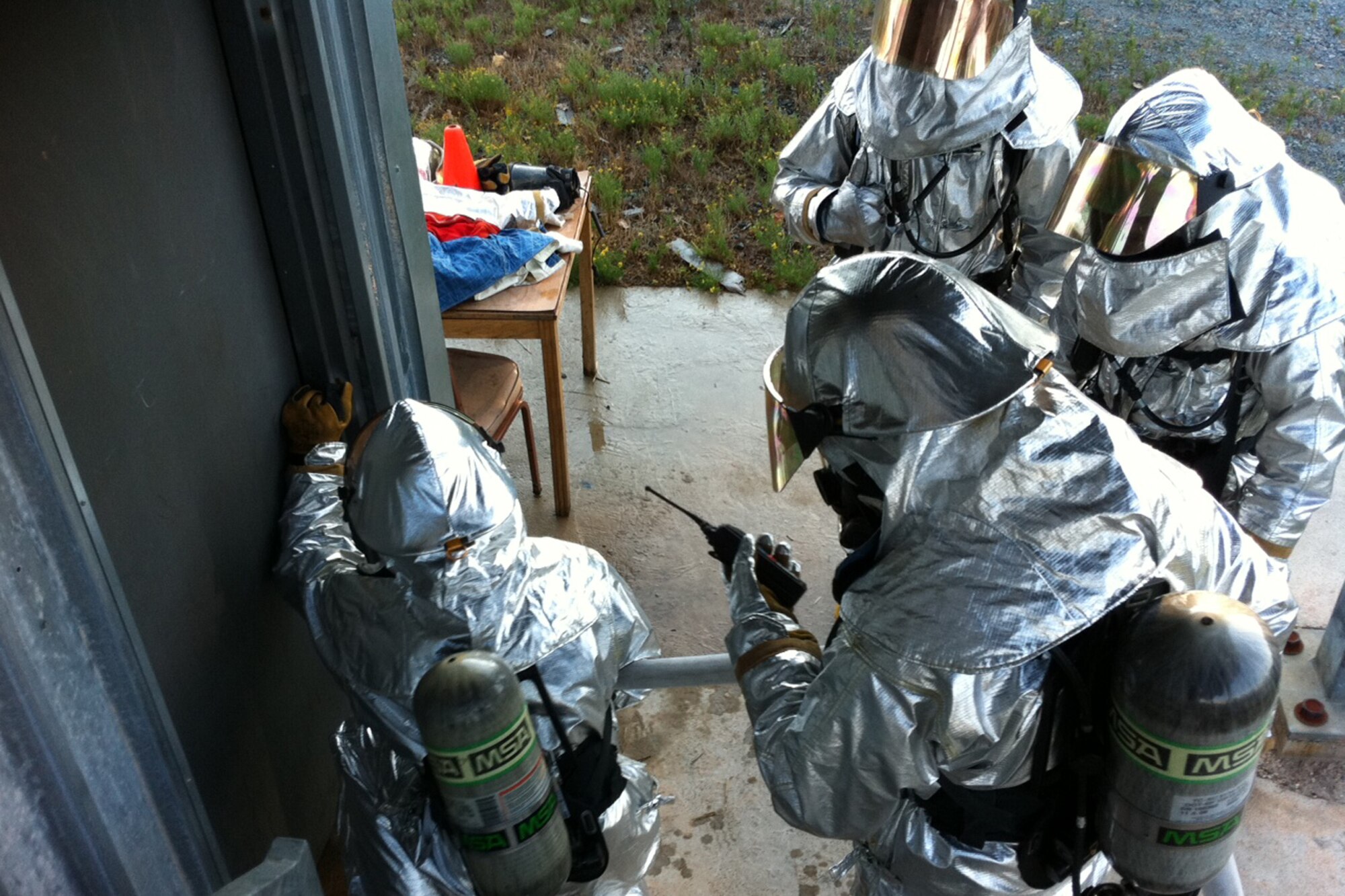 Firefighters with the 307th Civil Engineering Squadron practice communication and entry techniques during live fire structural training at Barksdale Air Force Base, La., Aug. 6, 2011. The training took place at the base fire training facility and involved 20 firefighters. The annual exercise was designed to provide training on putting out commercial and residential fires. (Courtesy photo)