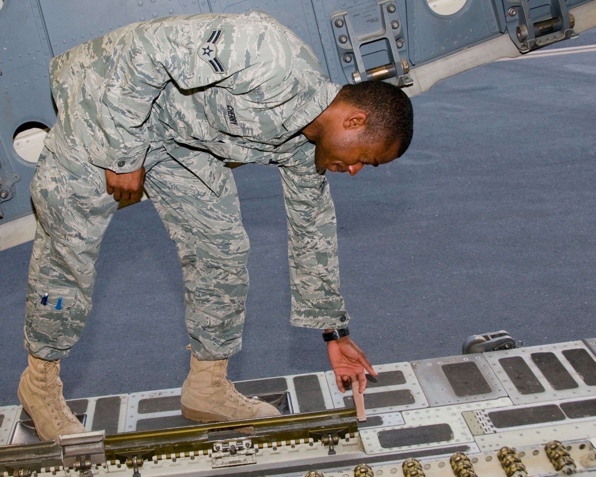 Airman 1st Class Daniel Cherry, C-17 Globemaster III loadmaster, points out the D-ring which nearly cost him a finger, July 30. The loadmaster was loading cargo when his finger was smashed between the loading rail and a 4,000 pound pallet, causing a near amputation.  Cherry is deployed from Charleston Air Force Base, S.C. (U.S. Air Force photo/Senior Airman Eric Summers Jr.)